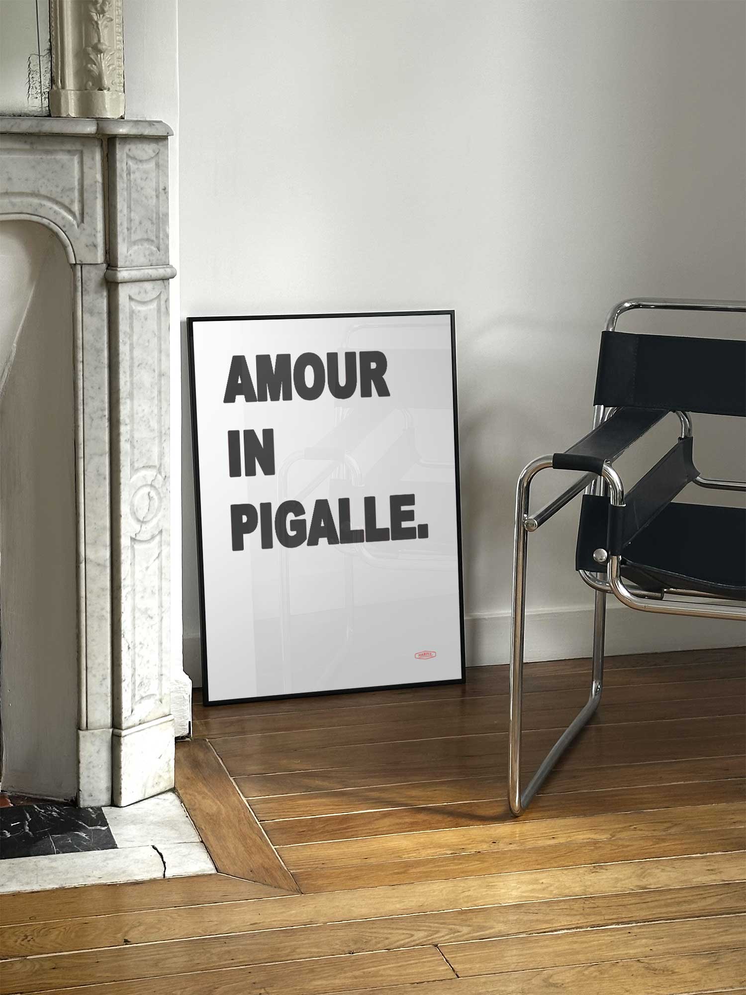 Affiche Amour in Pigalle de Haritz posée près d'une cheminée en marbre avec chaise design dans un salon d'appartement parisien.