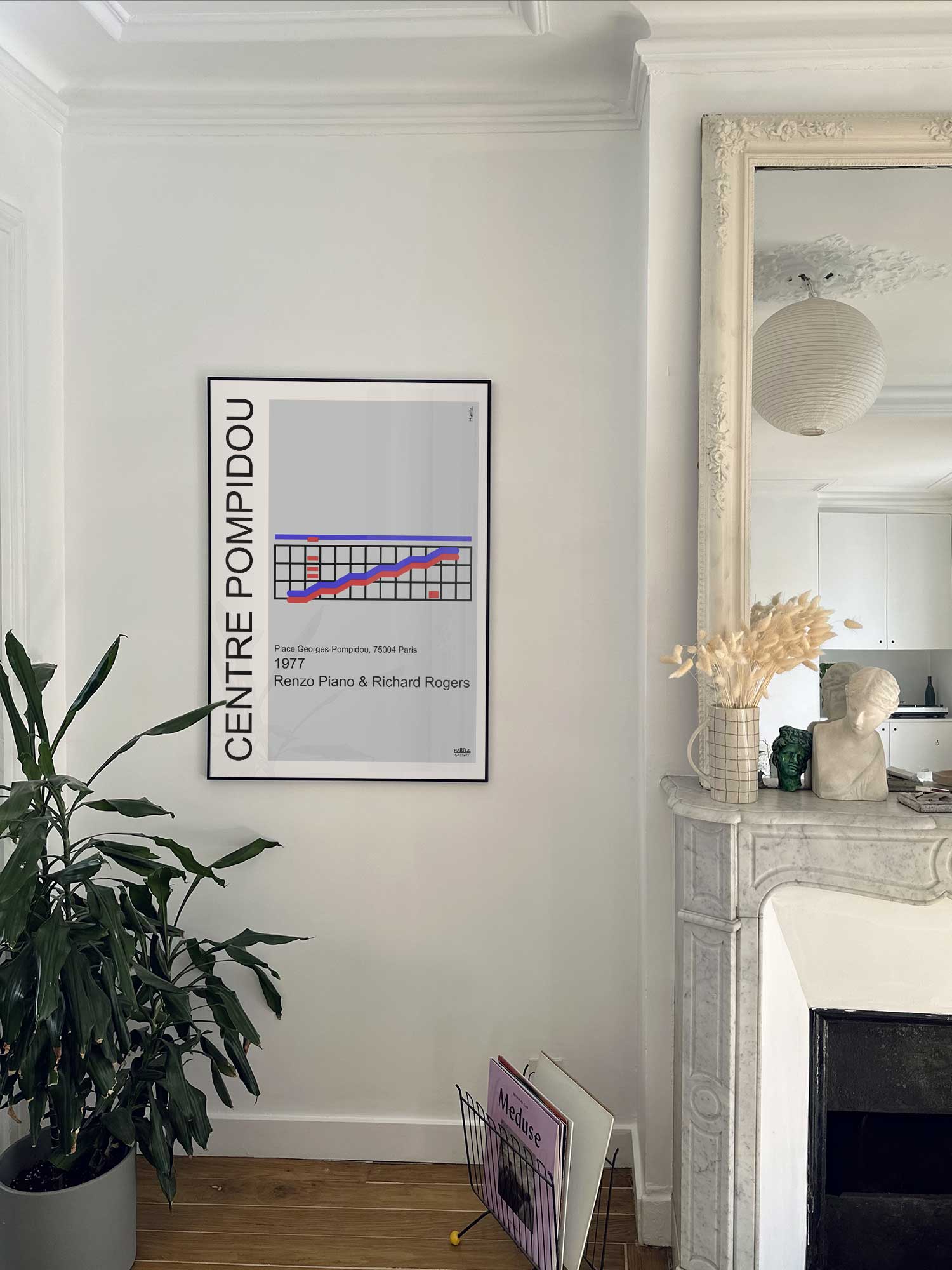 Affiche Centre Pompidou de Haritz accrochée au mur près d'une cheminée en marbre dans un appartement parisien.