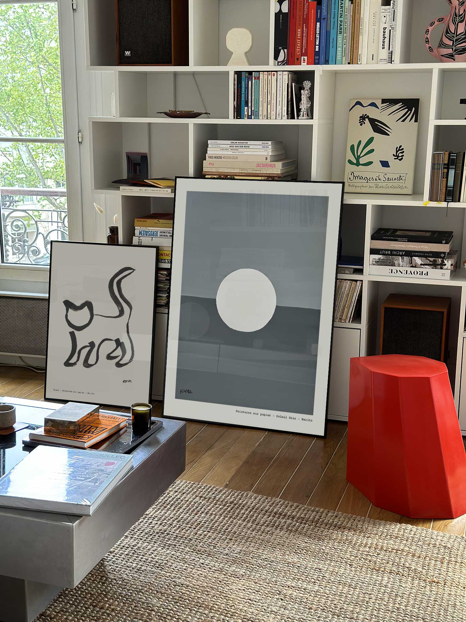 Affiche Lune de Haritz grand format dans un salon parisien design devant une bibliothèque blanche avec livres d'art.