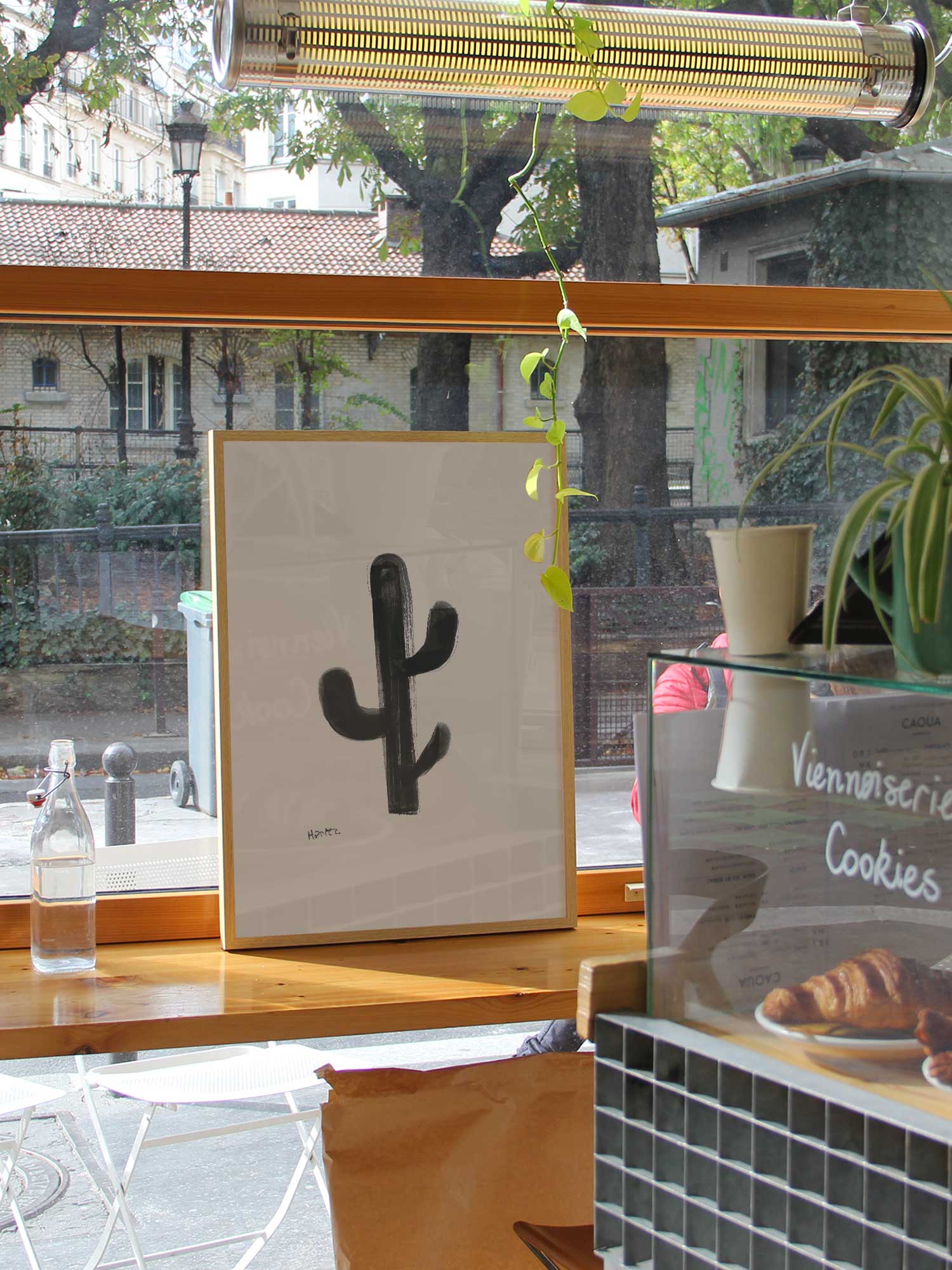 Affiche Cactus de Haritz dans un coffee shop parisien lumineux et branché avec vue sur rue.