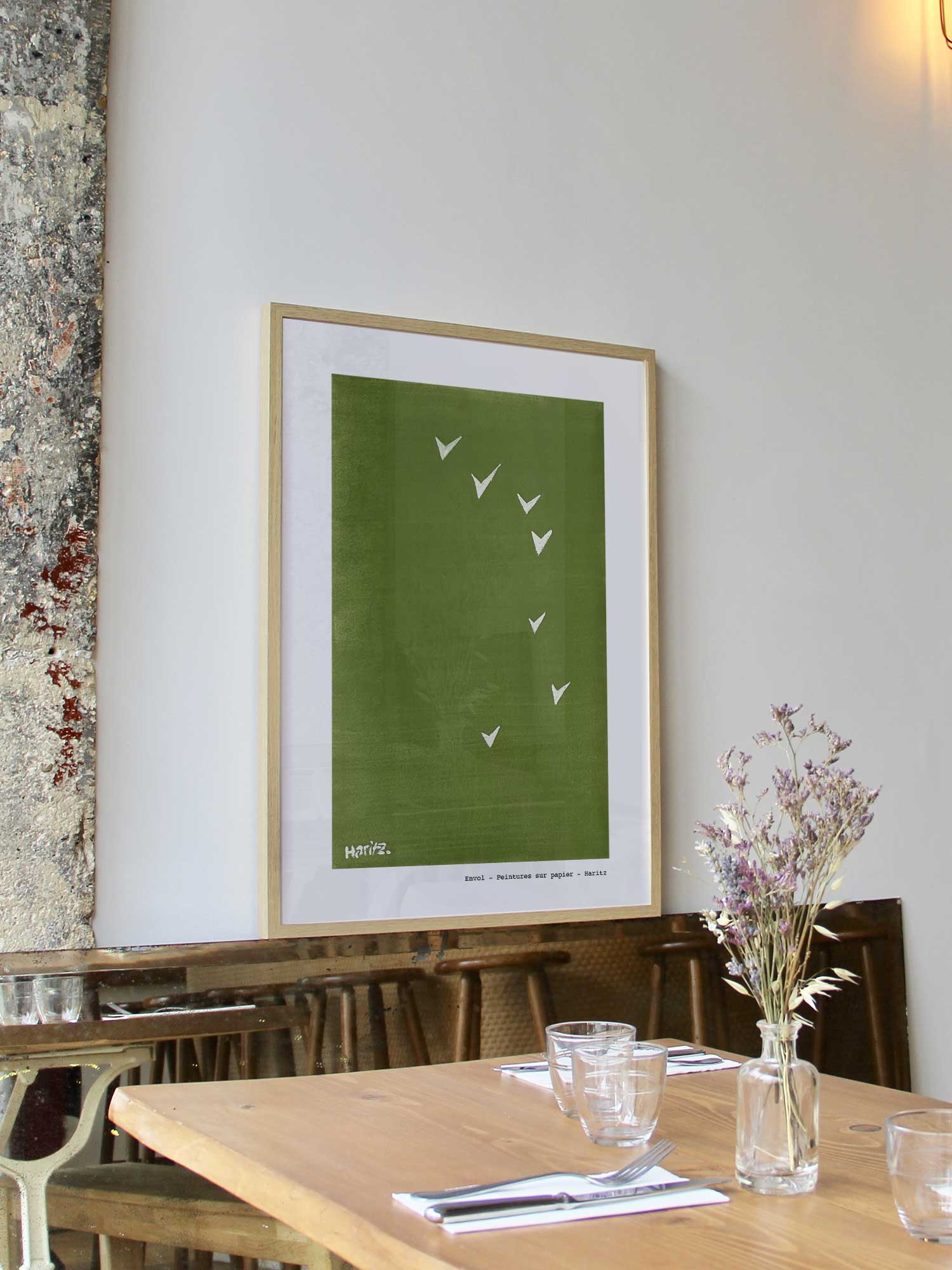 Affiche Envol de Haritz encadrée dans un restaurant bistrot parisien au style minimaliste et branché.