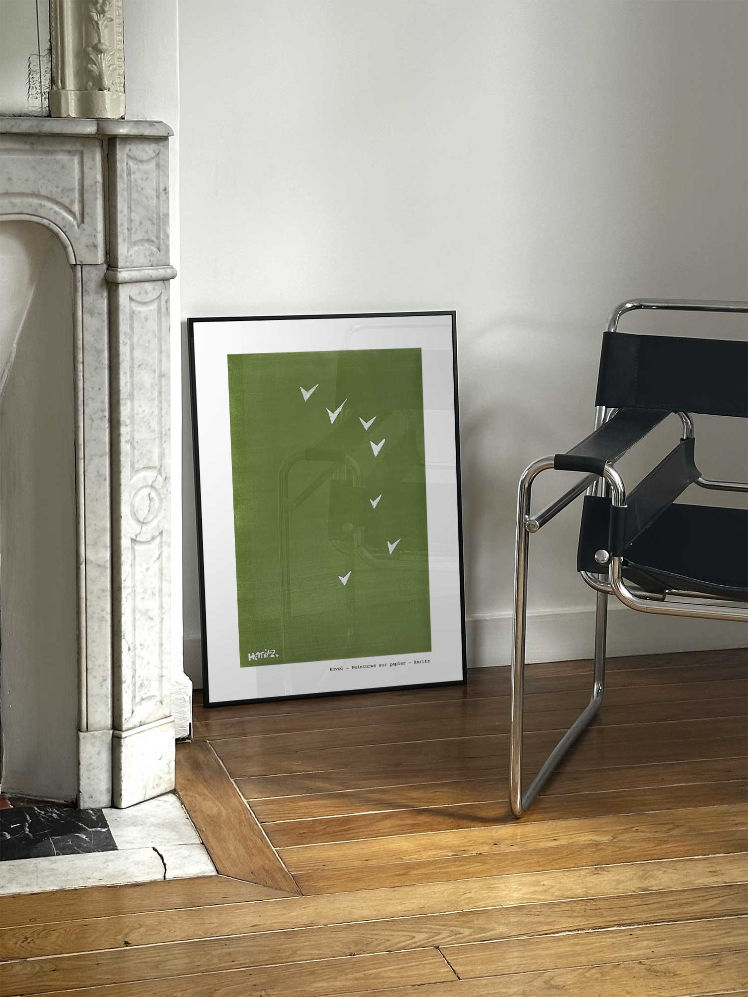 Affiche Envol de Haritz posée près d'une cheminée en marbre avec chaise design dans un salon d'appartement parisien.