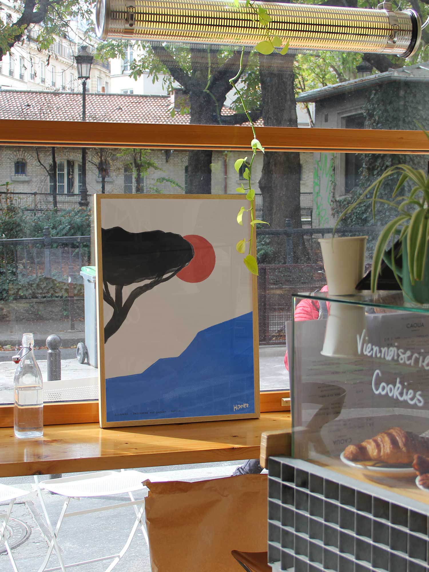 Affiche Littoral de Haritz dans un coffee shop parisien lumineux et branché avec vue sur rue.