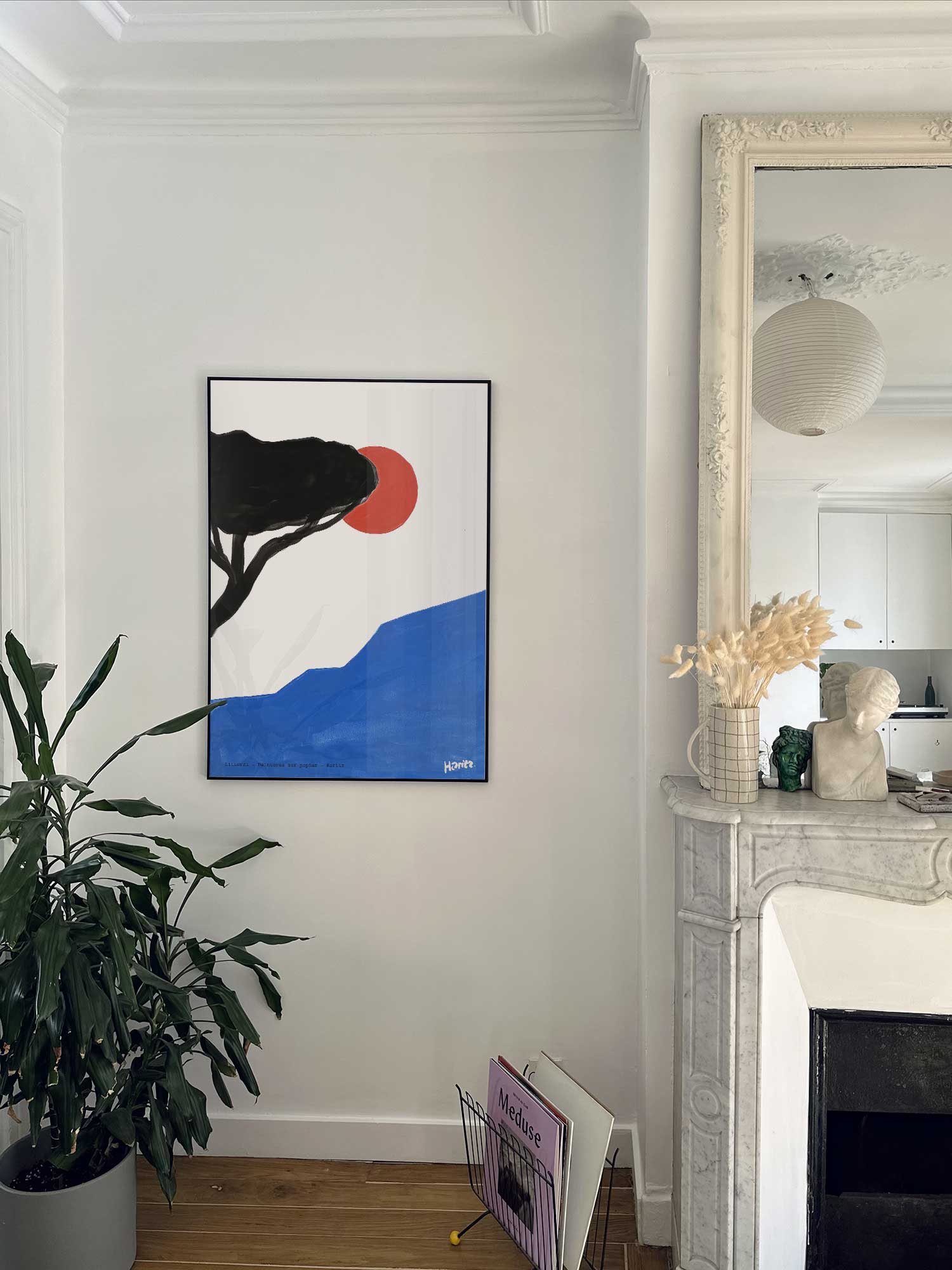 Affiche Littoral de Haritz accrochée au mur près d'une cheminée en marbre dans un appartement parisien.