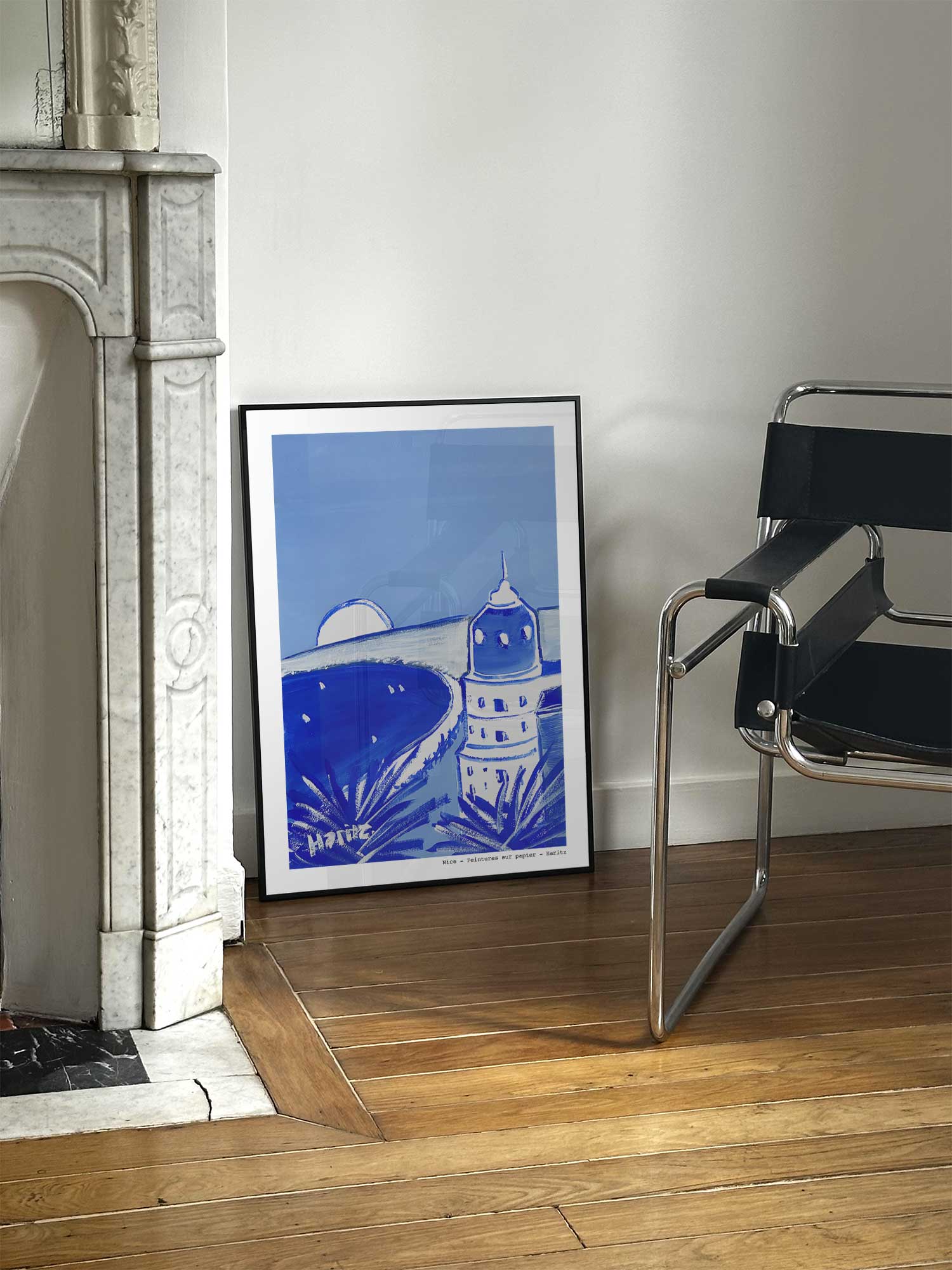 Affiche Nice de Haritz posée près d'une cheminée en marbre avec chaise design dans un salon d'appartement parisien.