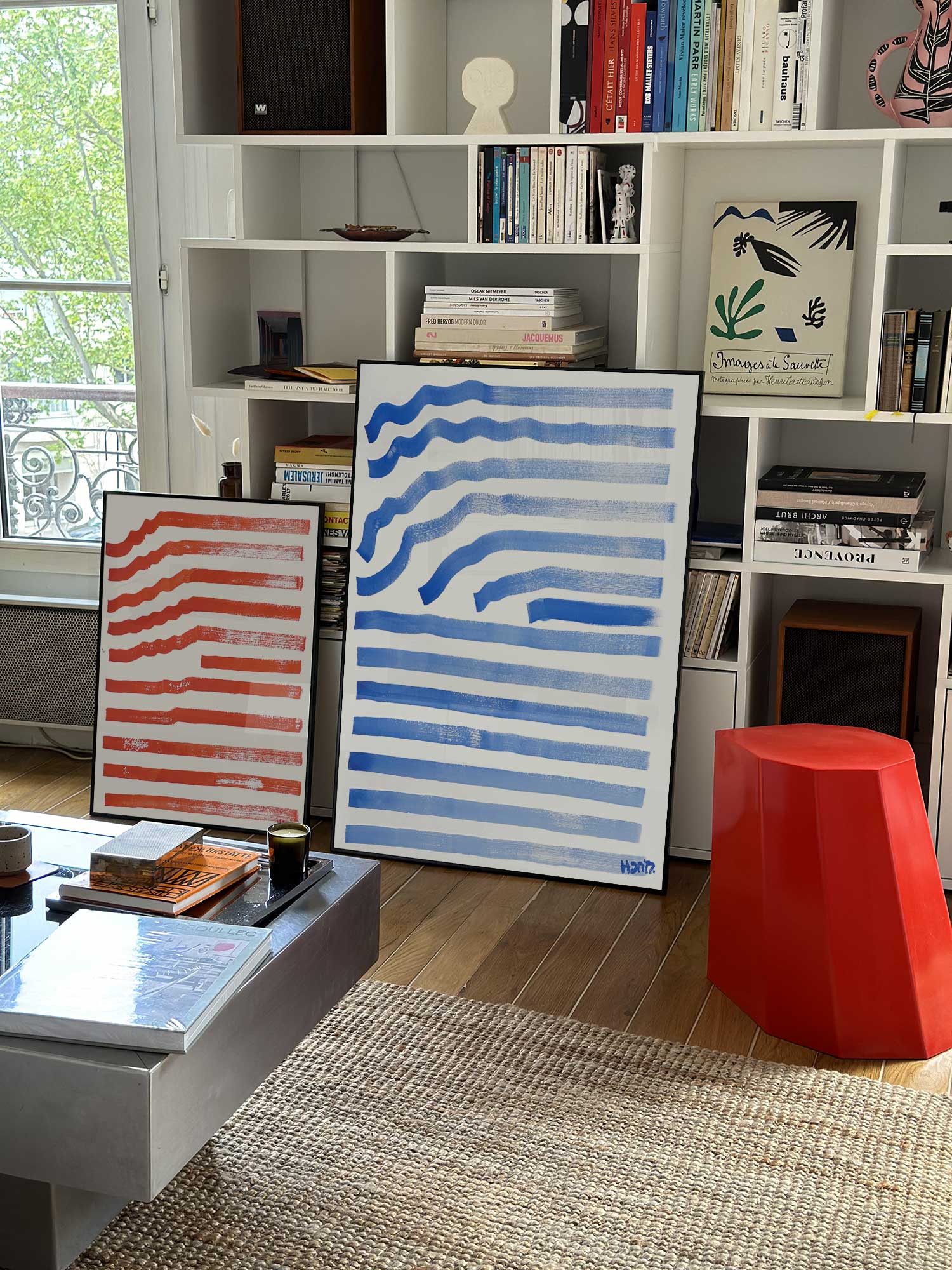 Affiche Ondes bleues de Haritz grand format dans un salon parisien design devant une bibliothèque blanche avec livres d'art.