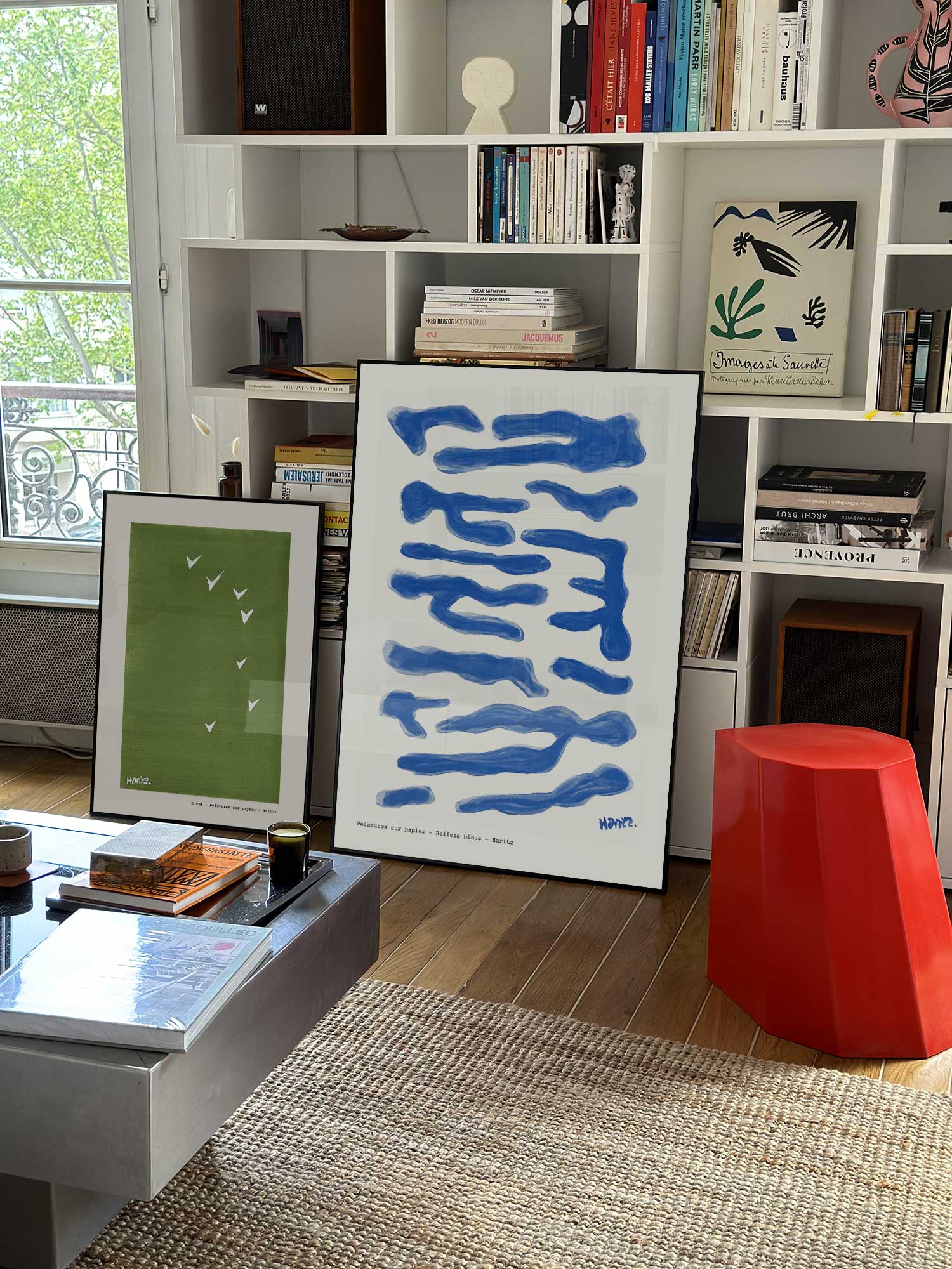 Affiche Reflets Bleus de Haritz grand format dans un salon parisien design devant une bibliothèque blanche avec livres d'art.
