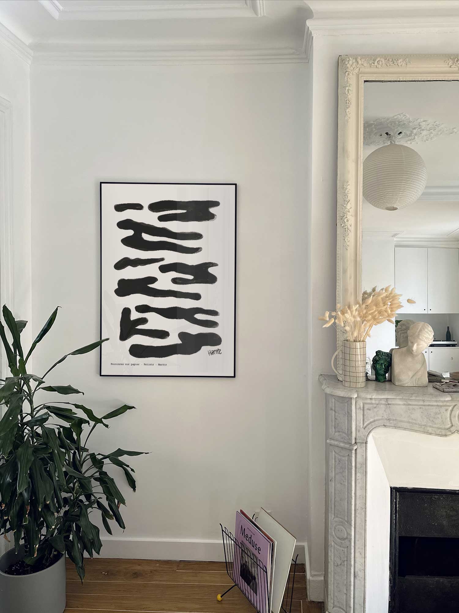 Affiche Reflets noirs de Haritz accrochée au mur près d'une cheminée en marbre dans un appartement parisien.