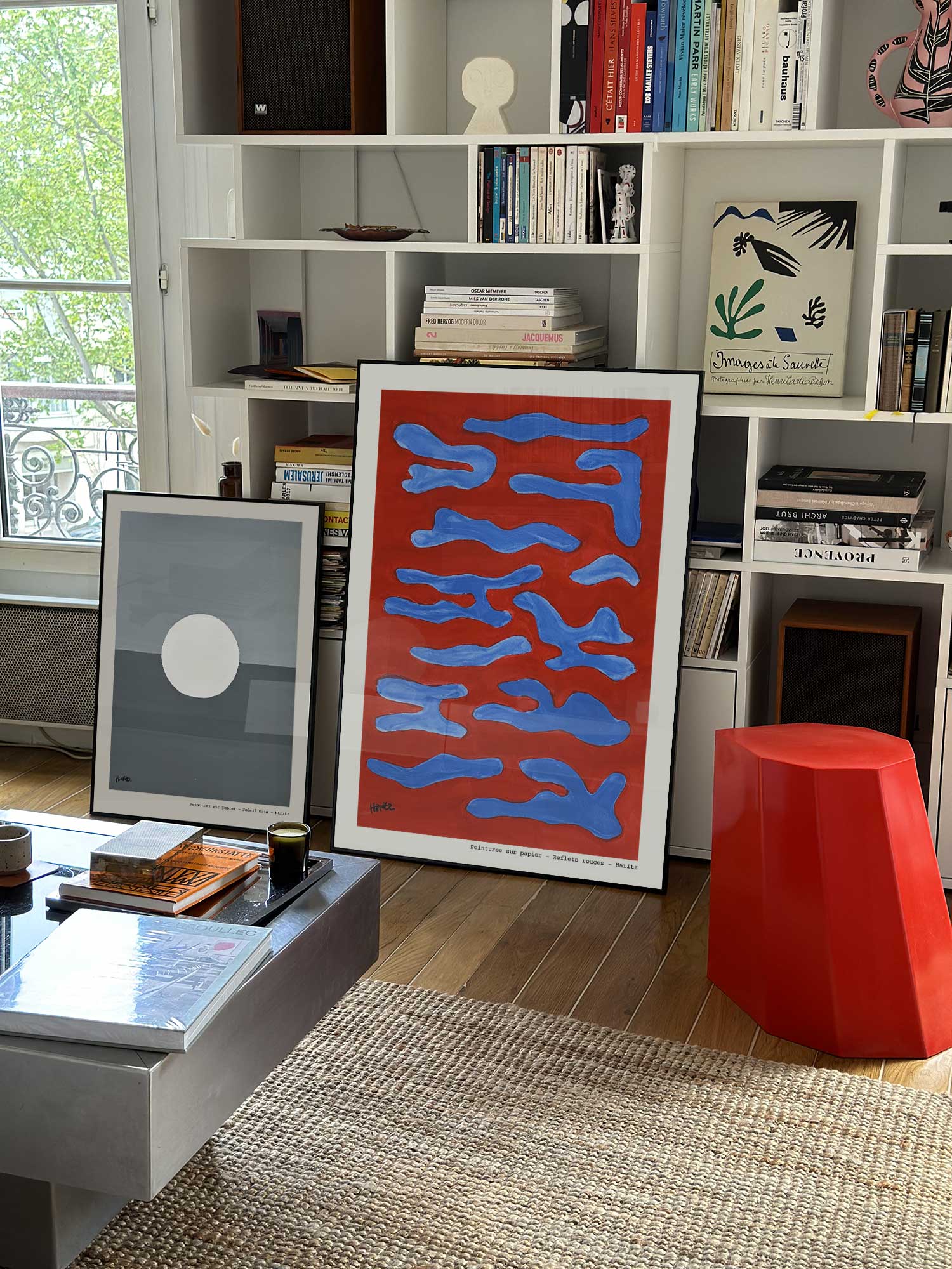 Affiche Reflets rouges de Haritz grand format dans un salon parisien design devant une bibliothèque blanche avec livres d'art.