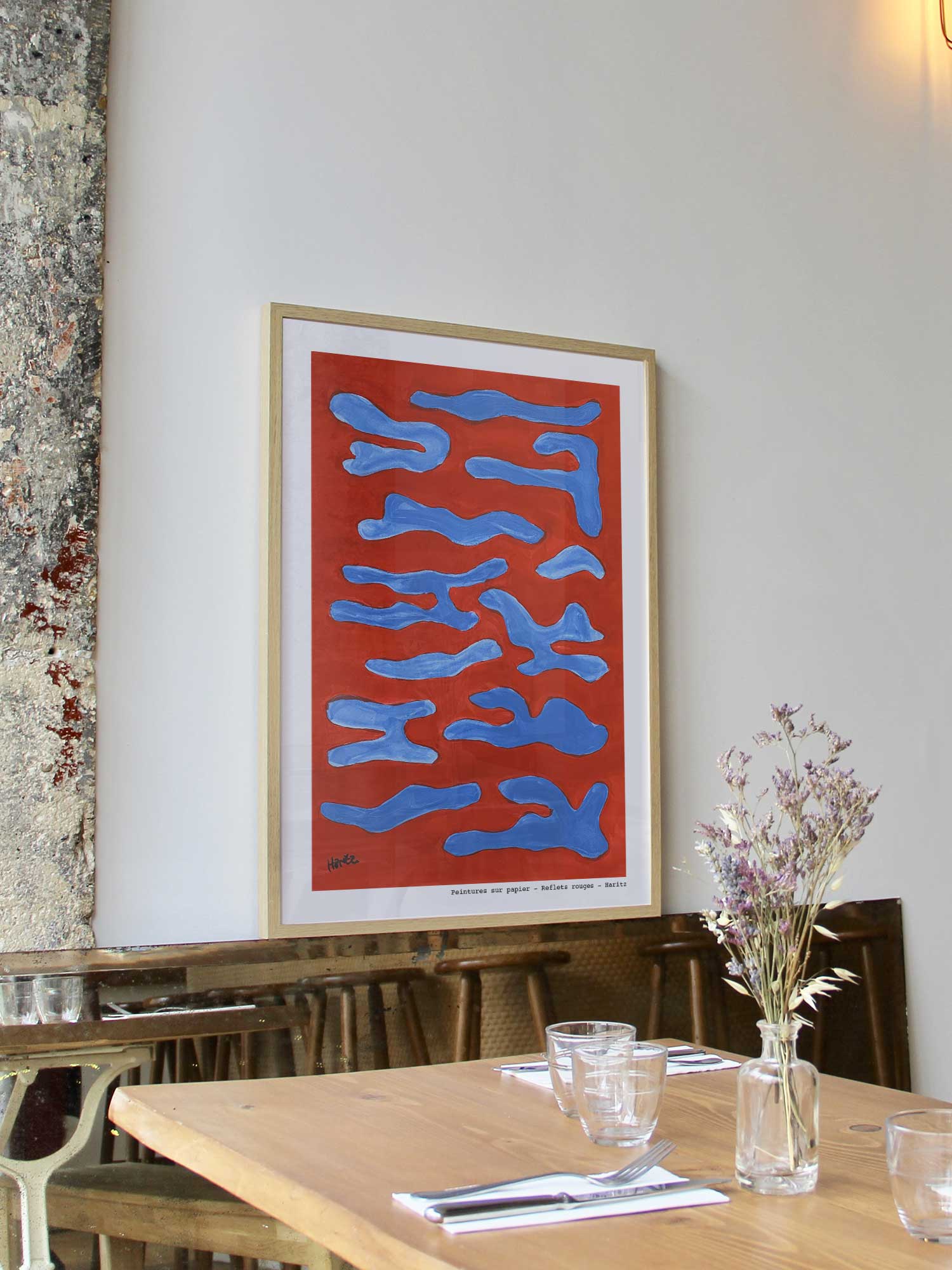 Affiche Reflets rouges de Haritz encadrée dans un restaurant bistrot parisien au style minimaliste et branché.