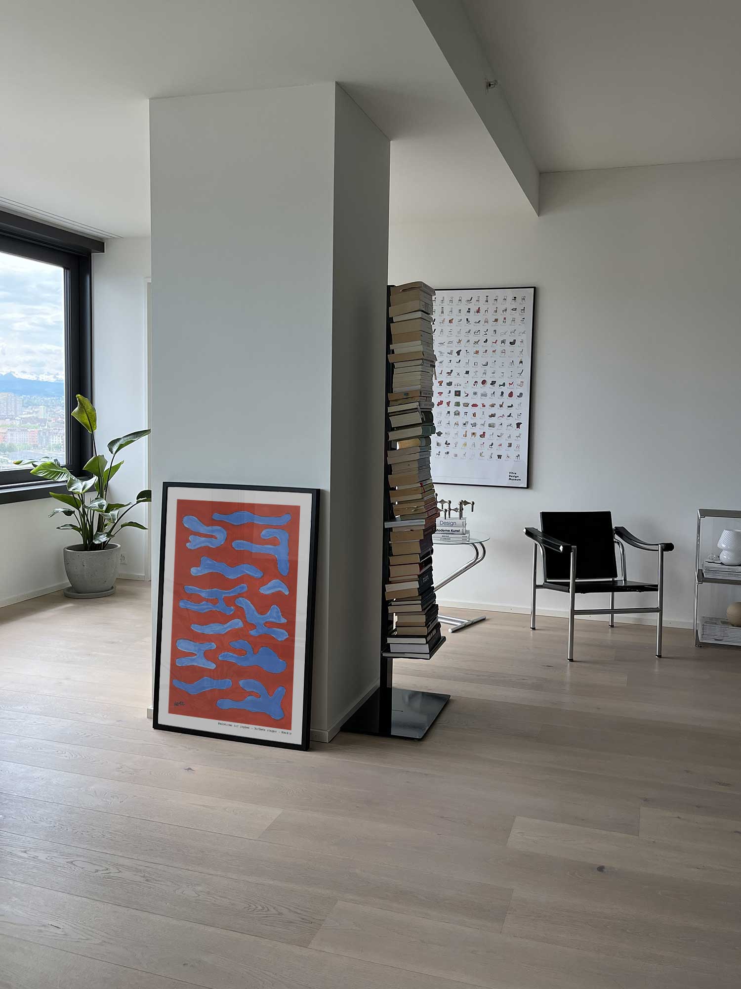 Affiche Reflets rouges de Haritz posée au sol dans un salon moderne et lumineux.