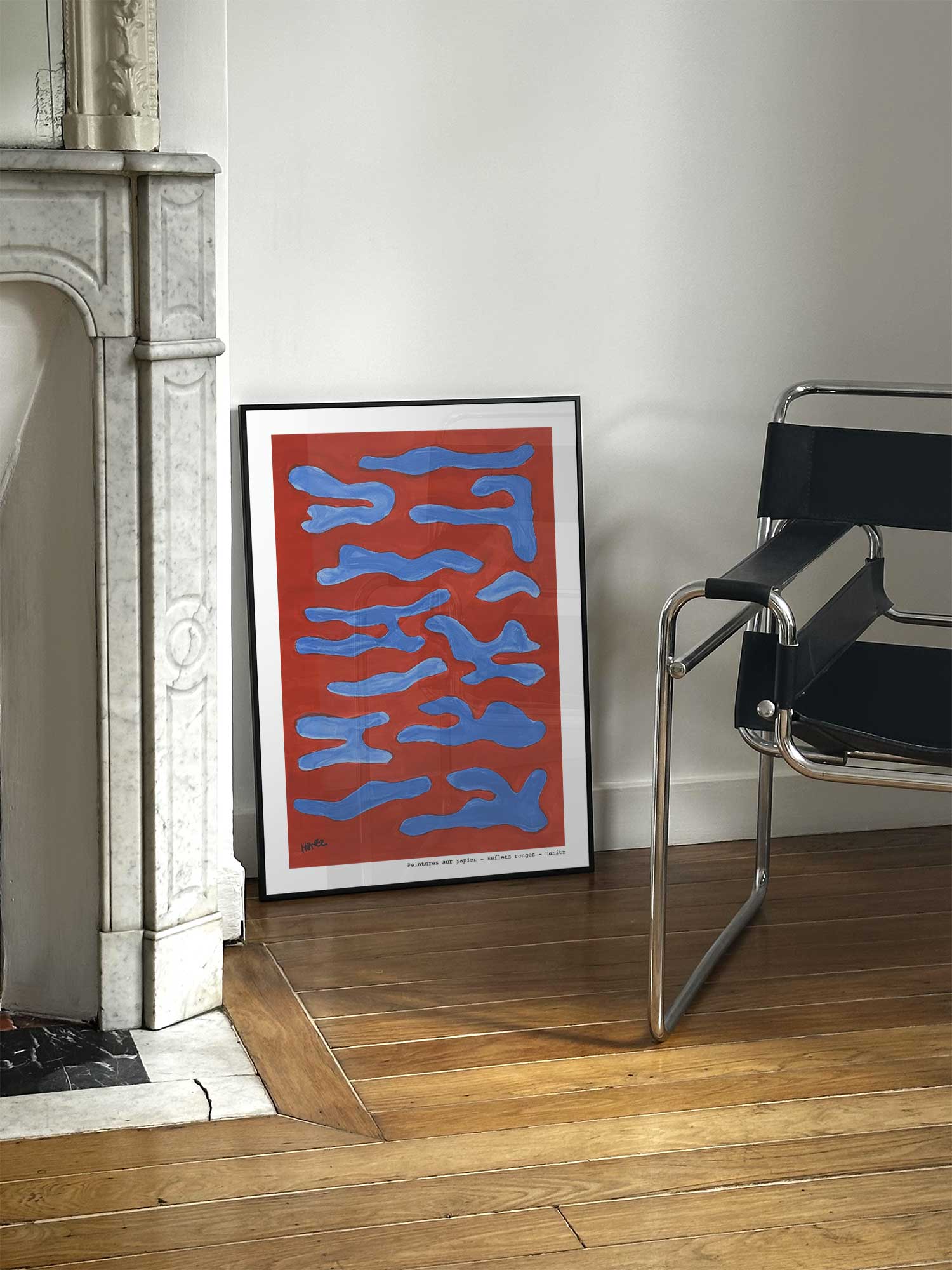 Affiche Reflets rouges de Haritz posée près d'une cheminée en marbre avec chaise design dans un salon d'appartement parisien.