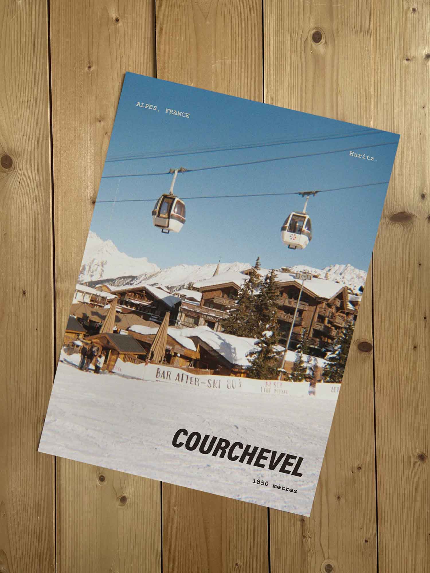 Affiche Courchevel vintage sans cadre posée sur parquet bois — village 1850 mètres, photographie argentique Haritz