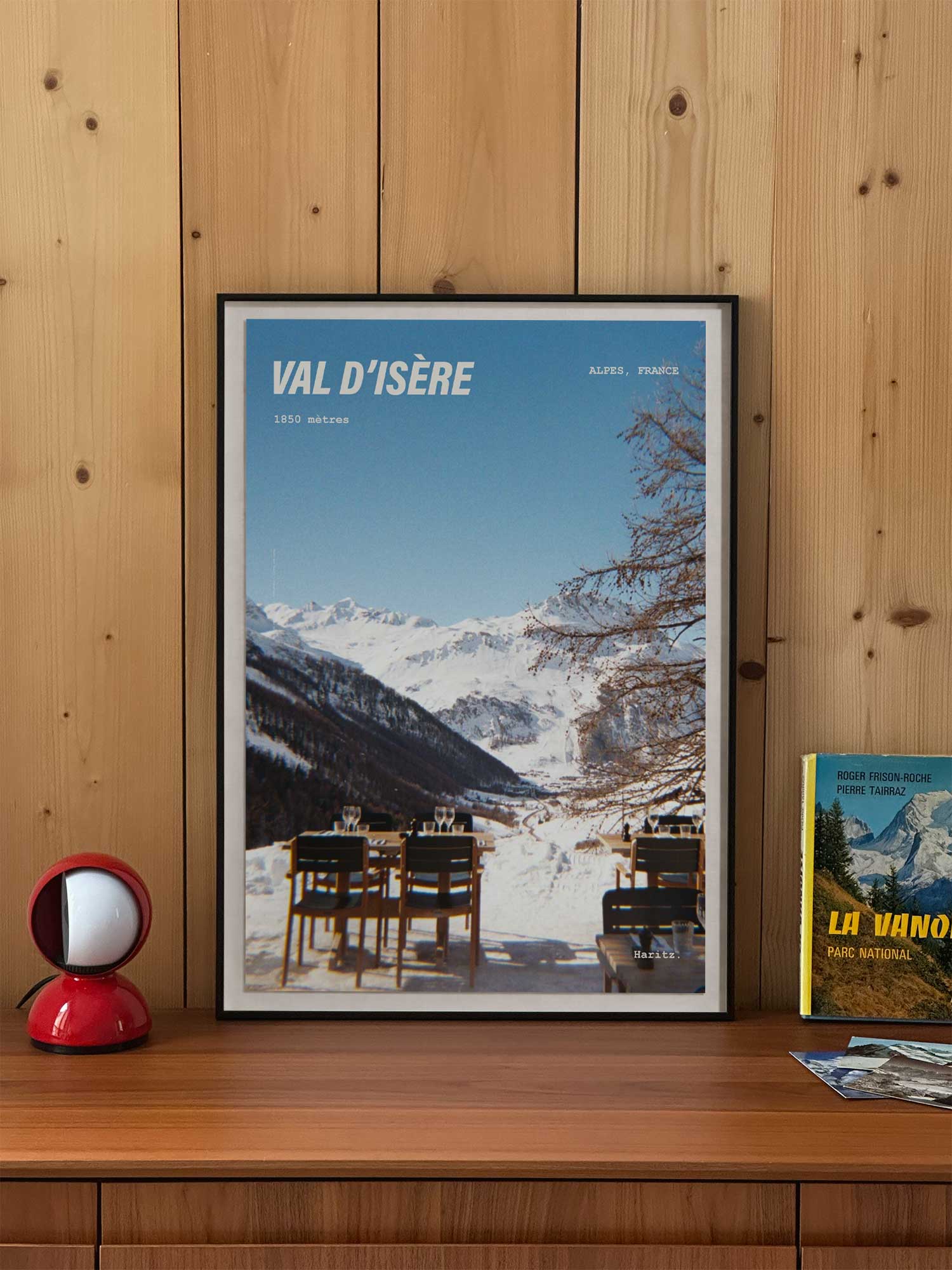 Affiche Val d'Isère vintage encadrée posée sur meuble en bois — terrasse de restaurant en altitude à 1850 mètres, photographie argentique Haritz