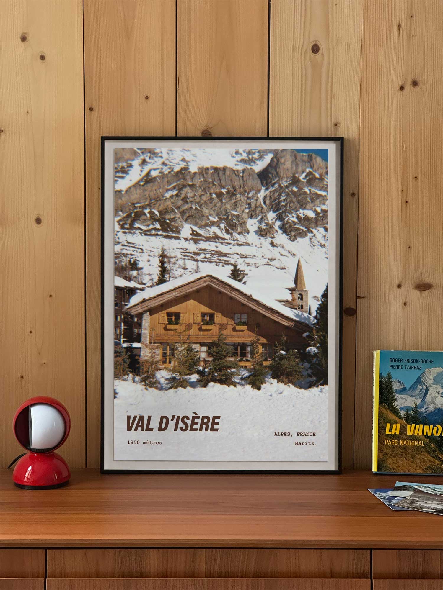 Affiche Val d'Isère vintage encadrée posée sur meuble en bois — chalet savoyard et clocher du village à 1850 mètres, photographie argentique Haritz