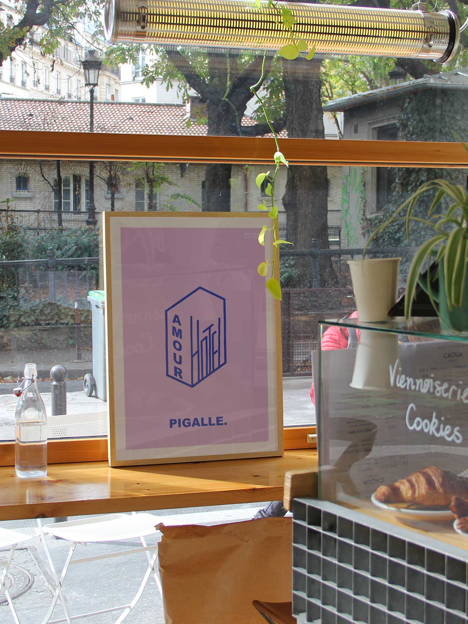 Affiche Hotel AMour de Haritz dans un coffee shop parisien branché et lumineux avec vue sur rue.