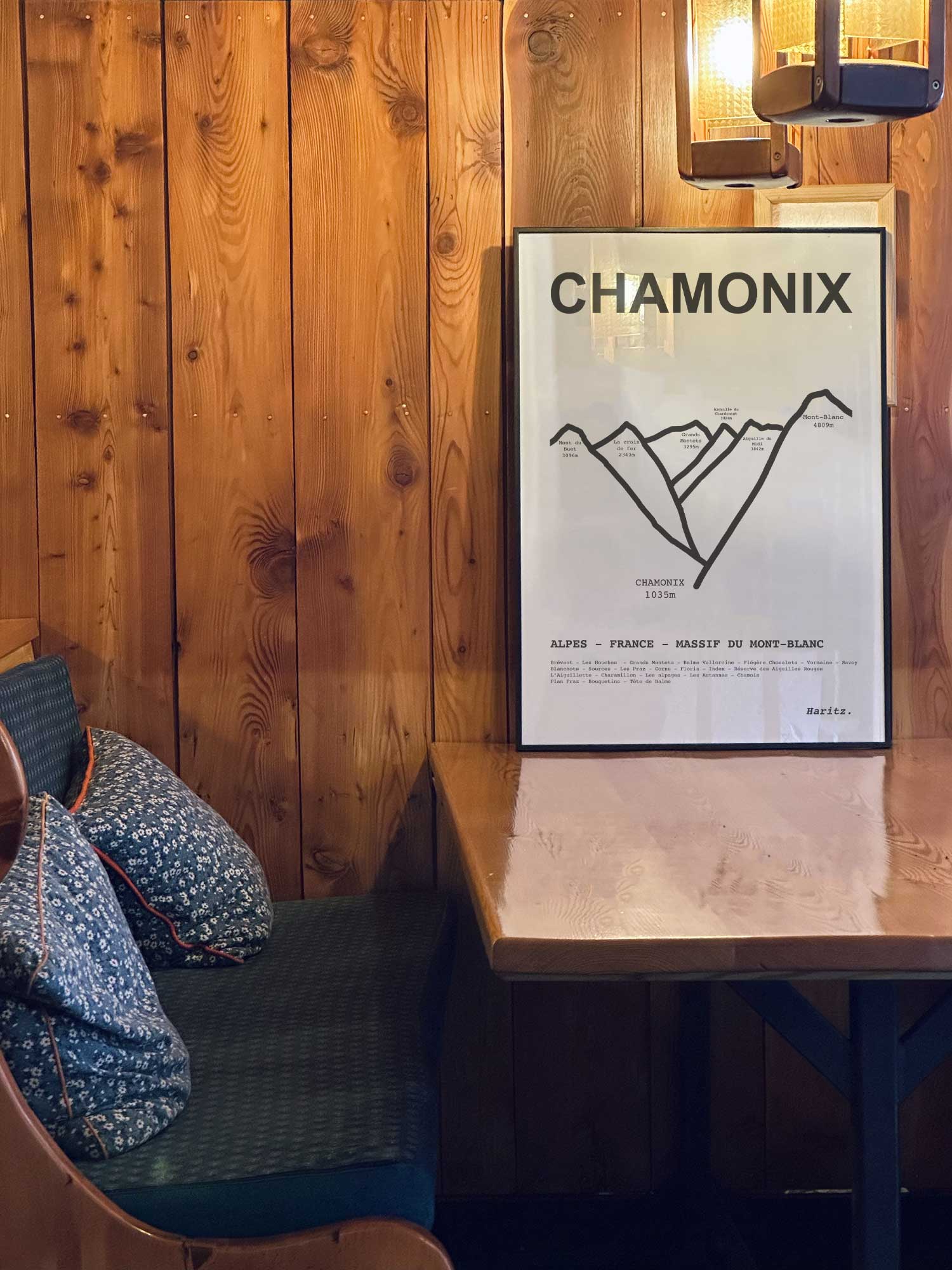 Affiche Chamonix des sommets topographiques encadrée dans un restaurant de montagne en bois avec ambiance chalet chaleureuse, décoration murale signée Haritz.