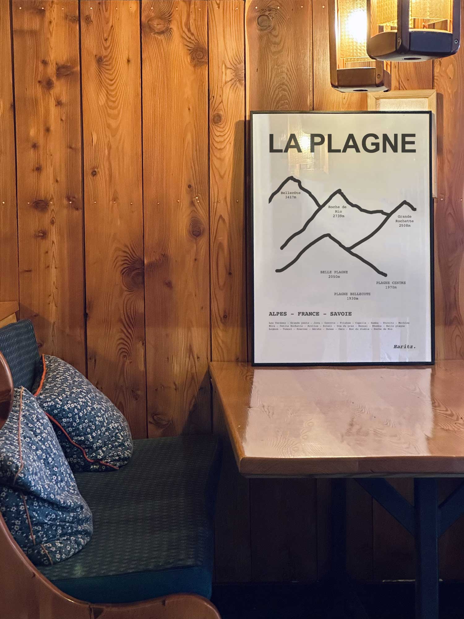 Affiche La Plagne des sommets topographiques encadrée dans un restaurant de montagne en bois avec ambiance chalet chaleureuse, décoration murale signée Haritz.