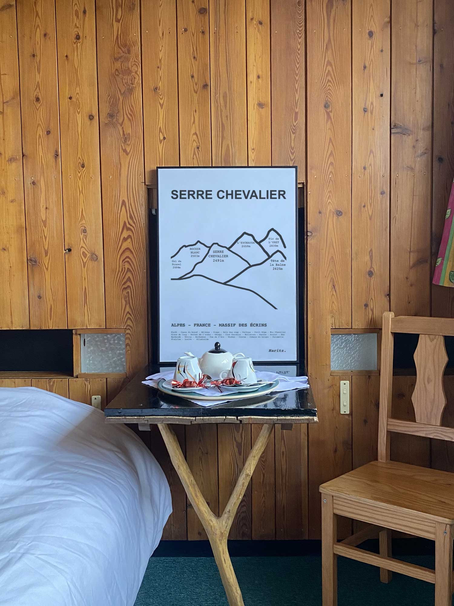 Affiche Serre Chevalier du tracé des sommets encadrée dans une chambre d’hôtel de montagne en bois, décoration murale style chalet par Haritz.