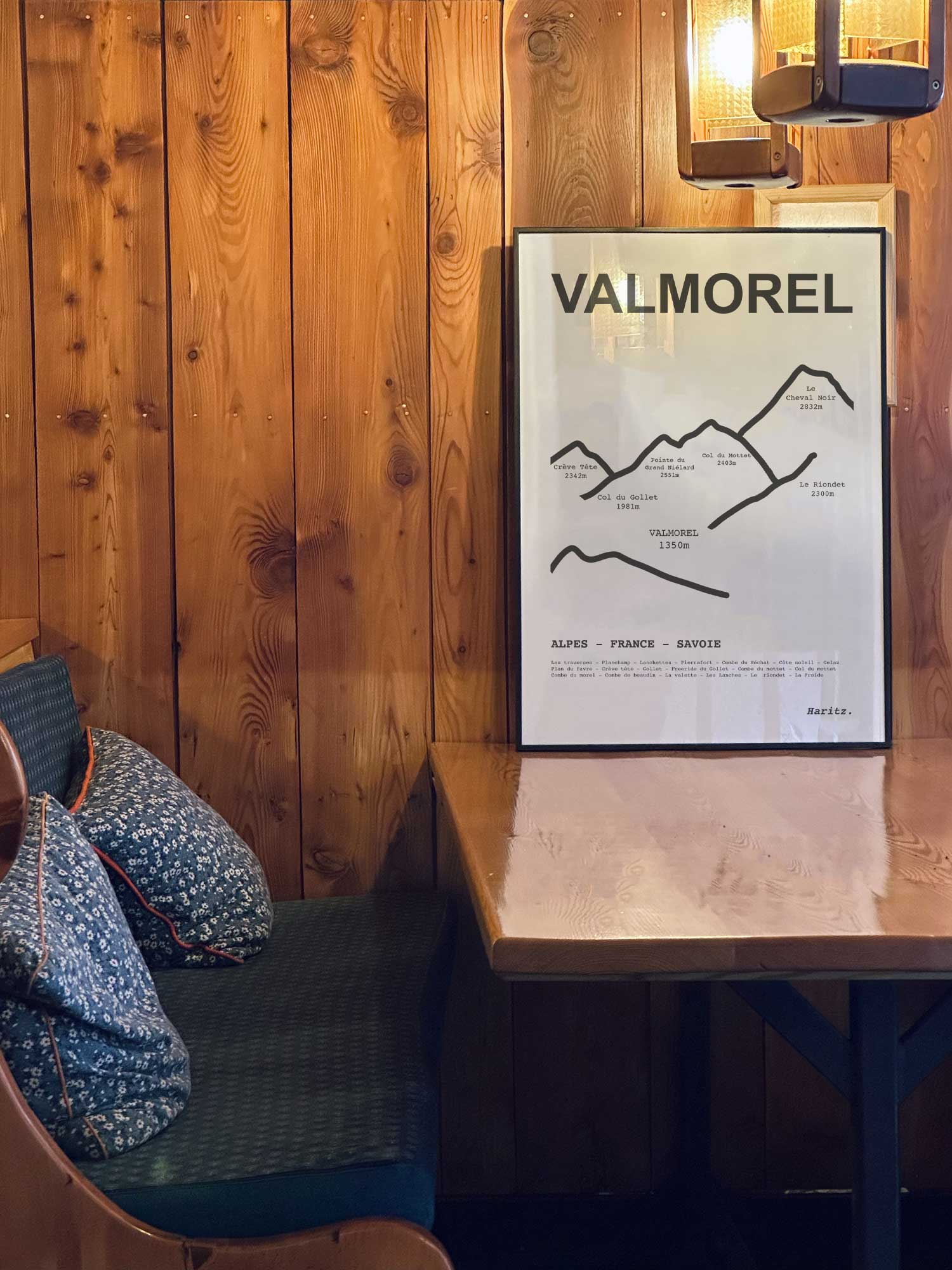 Affiche Valmorel des sommets topographiques encadrée dans un restaurant de montagne en bois avec ambiance chalet chaleureuse, décoration murale signée Haritz.