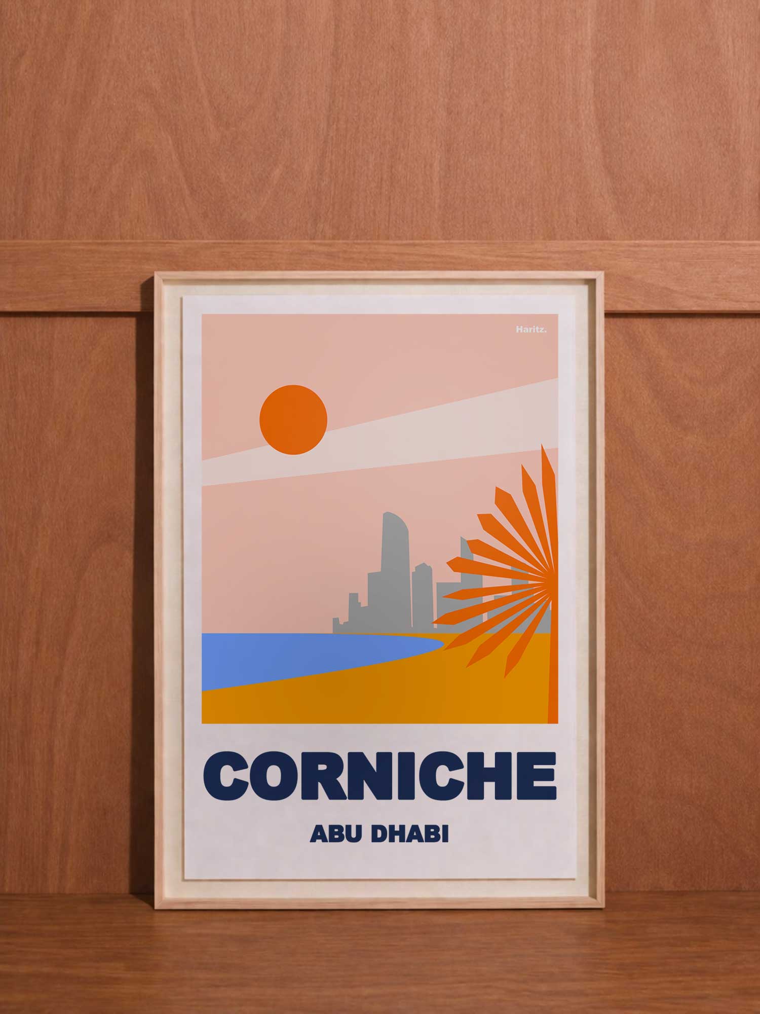 Affiche contemporaine Haritz "Corniche Abu Dhabi" - design graphique minimaliste rose corail et bleu représentant la skyline avec palmier et soleil, style vintage UAE, cadre bois naturel