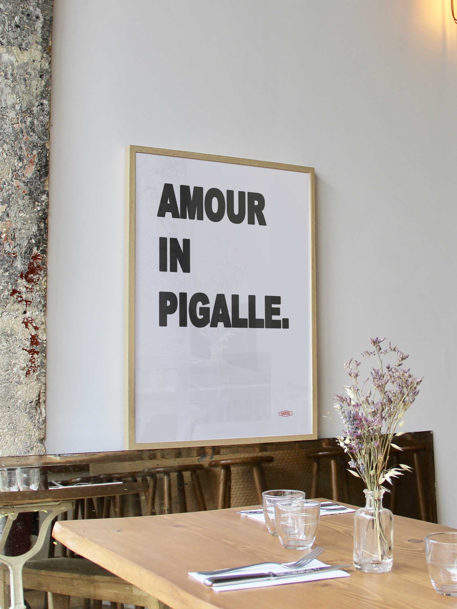 Affiche Amour In Pigalle de Haritz encadrée dans un restaurant bistrot parisien au style minimaliste et branché.