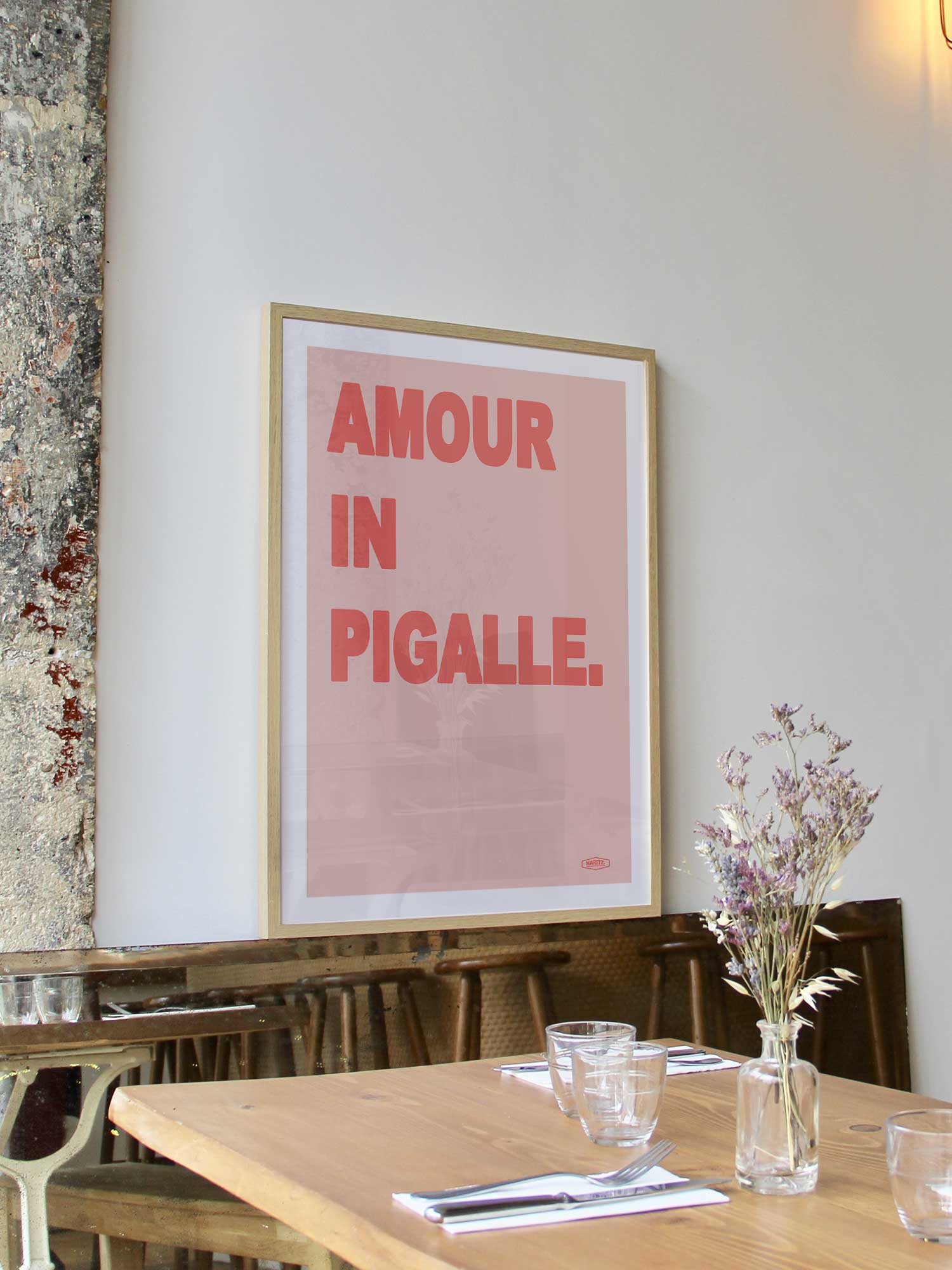Affiche Amour in Pigalle de Haritz encadrée dans un restaurant bistrot parisien au style minimaliste et branché.