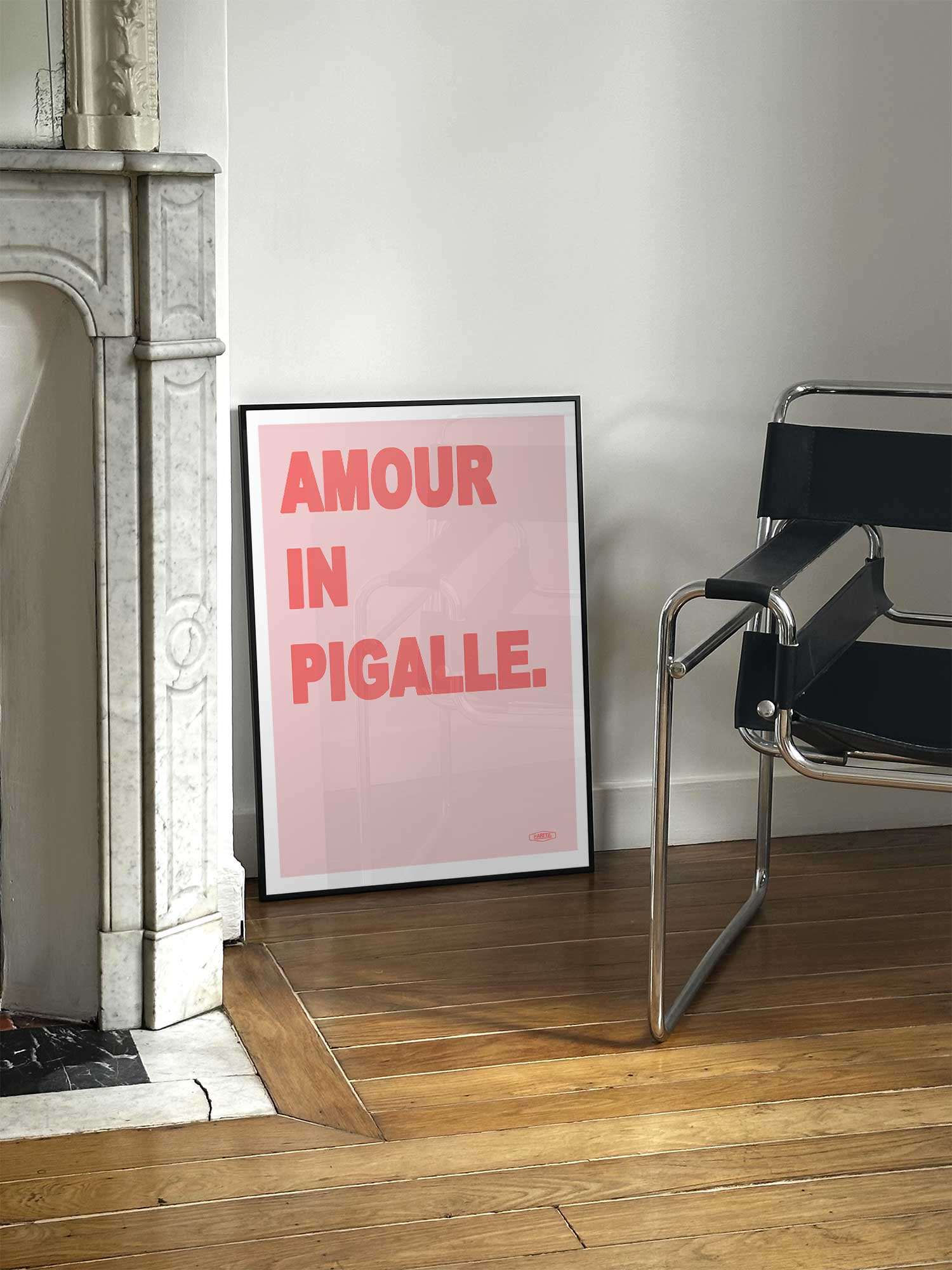 Affiche Amour in Pigalle version rose de Haritz posée près d'une cheminée en marbre avec chaise Design dans un salon d'appartement parisien.