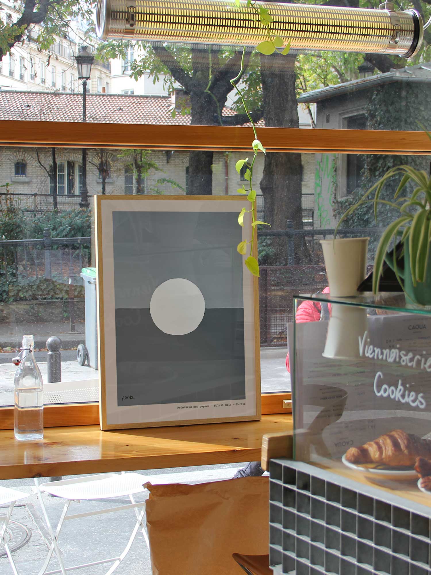 Affiche Lune de Haritz dans un coffee shop parisien lumineux et branché avec vue sur rue.