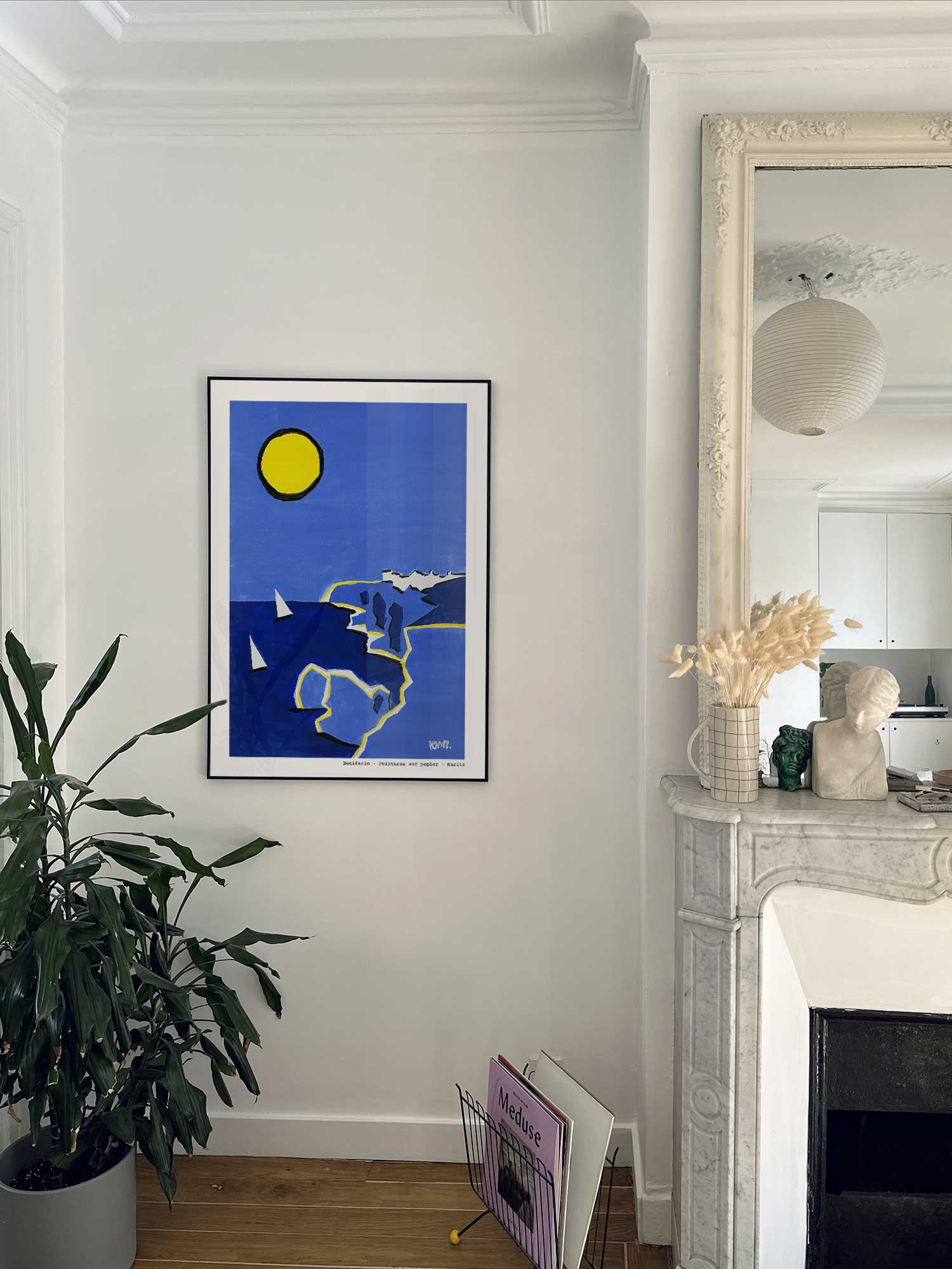 Affiche Bonifacio de Haritz accrochée au mur près d'une cheminée en marbre dans un appartement parisien.