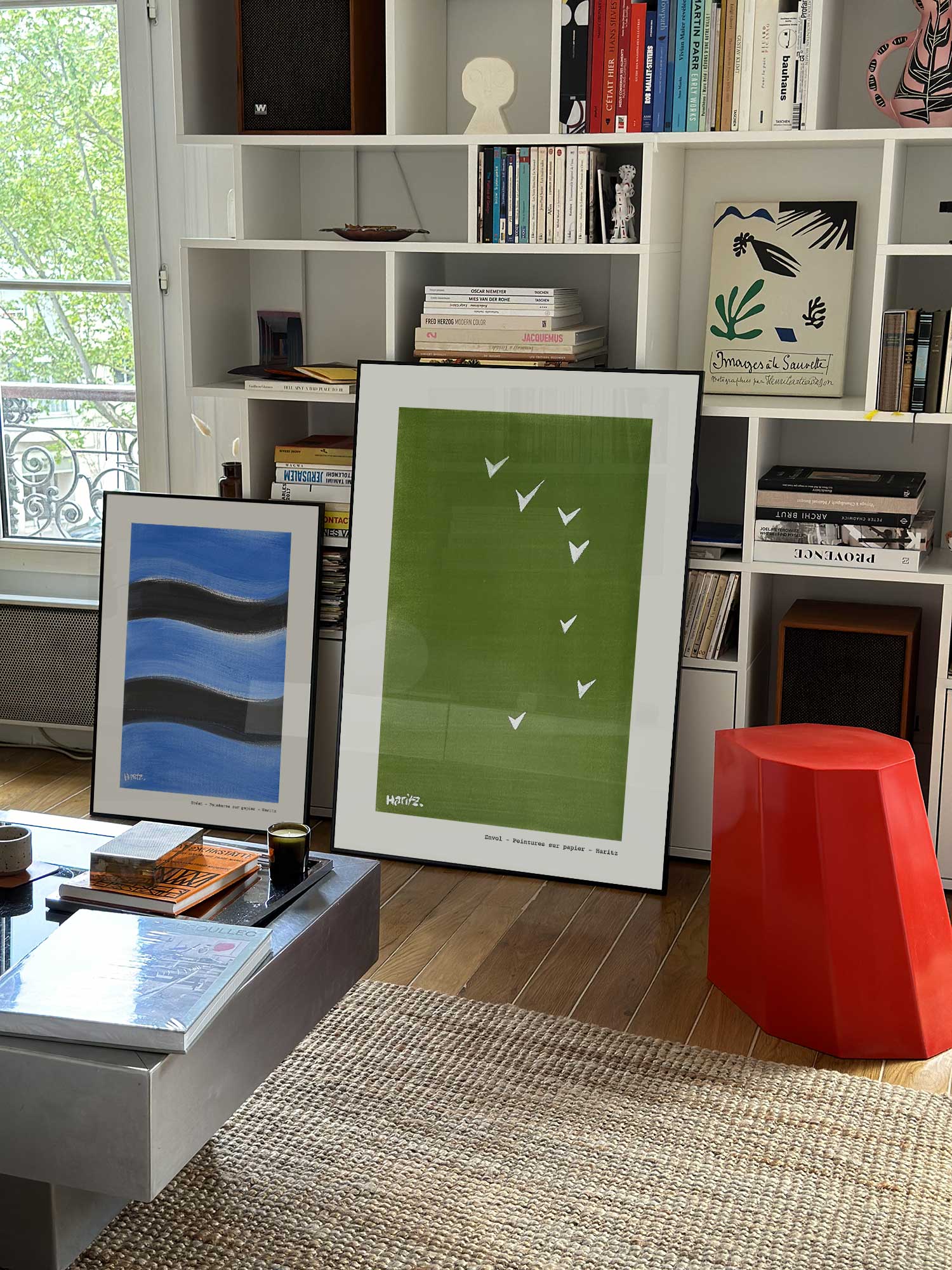 Affiche Envol de Haritz grand format dans un salon parisien design devant une bibliothèque blanche avec livres d'art.