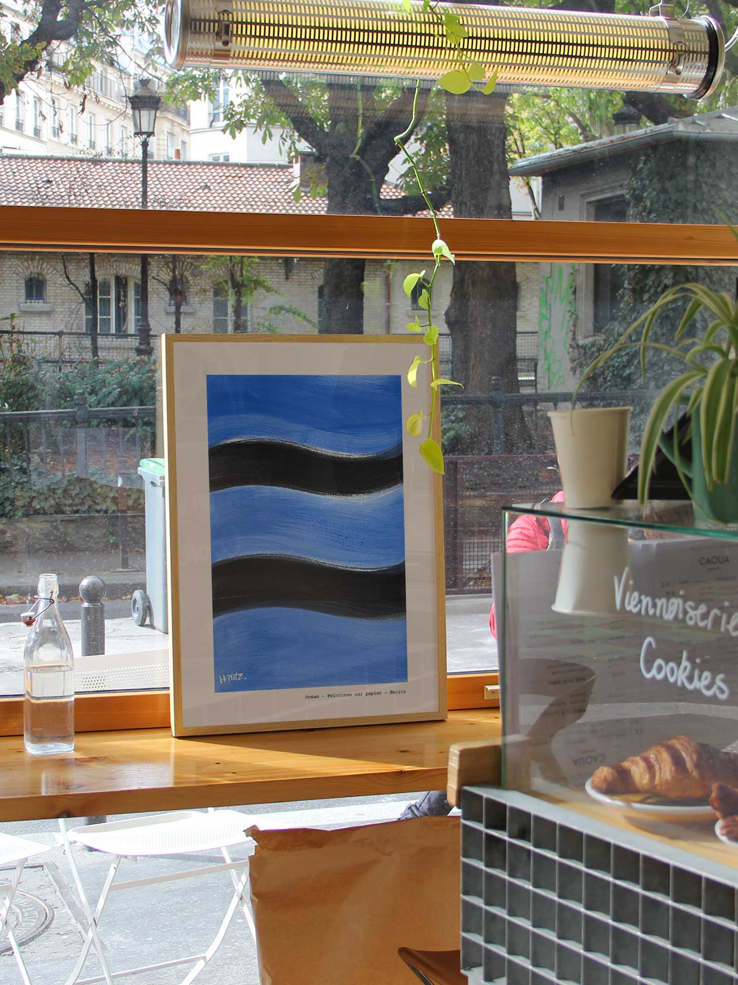 Affiche Ocean de Haritz dans un coffee shop parisien lumineux et branché avec vue sur rue.