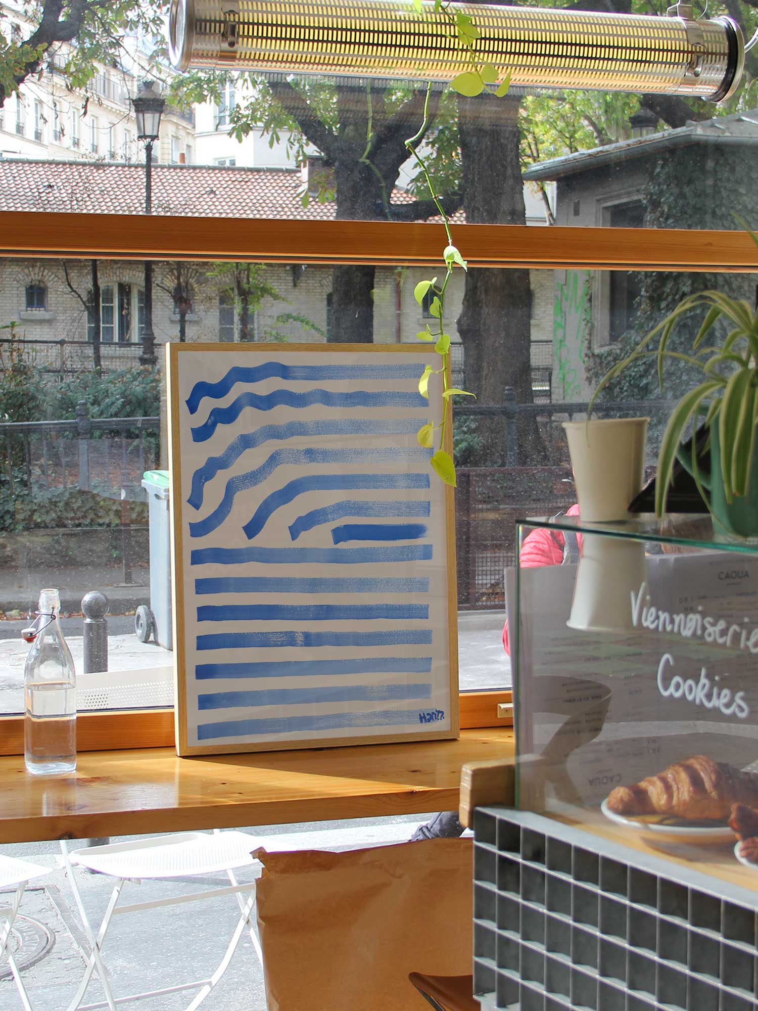Affiche Ondes bleues de Haritz dans un coffee shop parisien lumineux et branché avec vue sur rue.