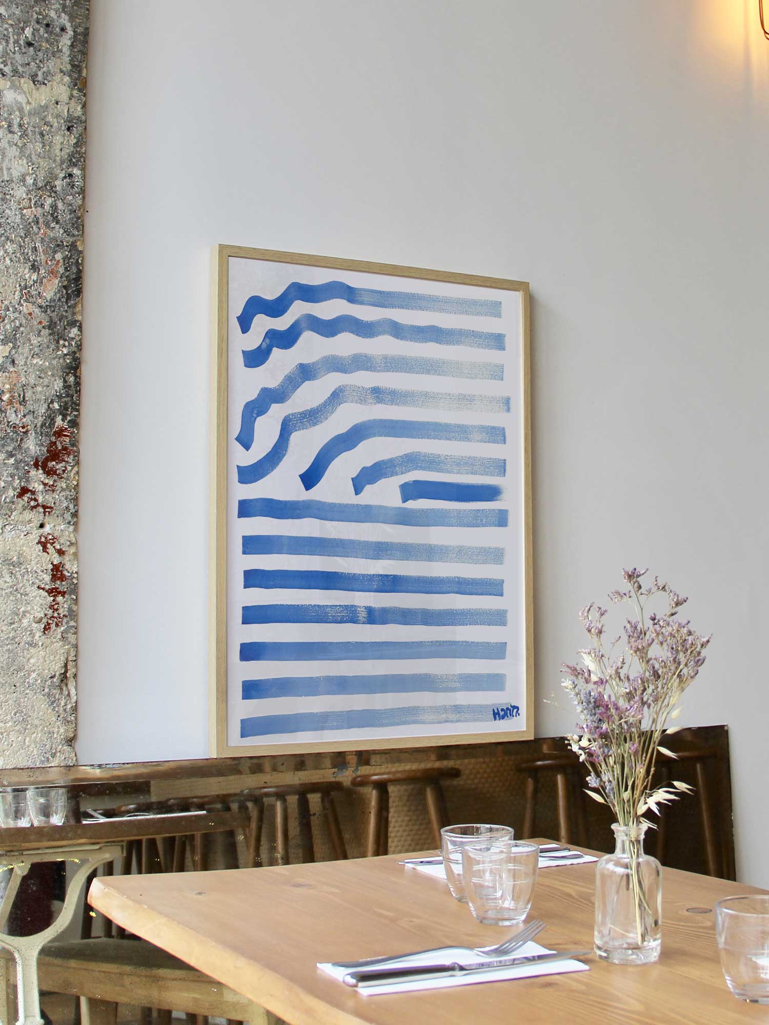 Affiche Ondes bleues de Haritz encadrée dans un restaurant bistrot parisien au style minimaliste et branché.