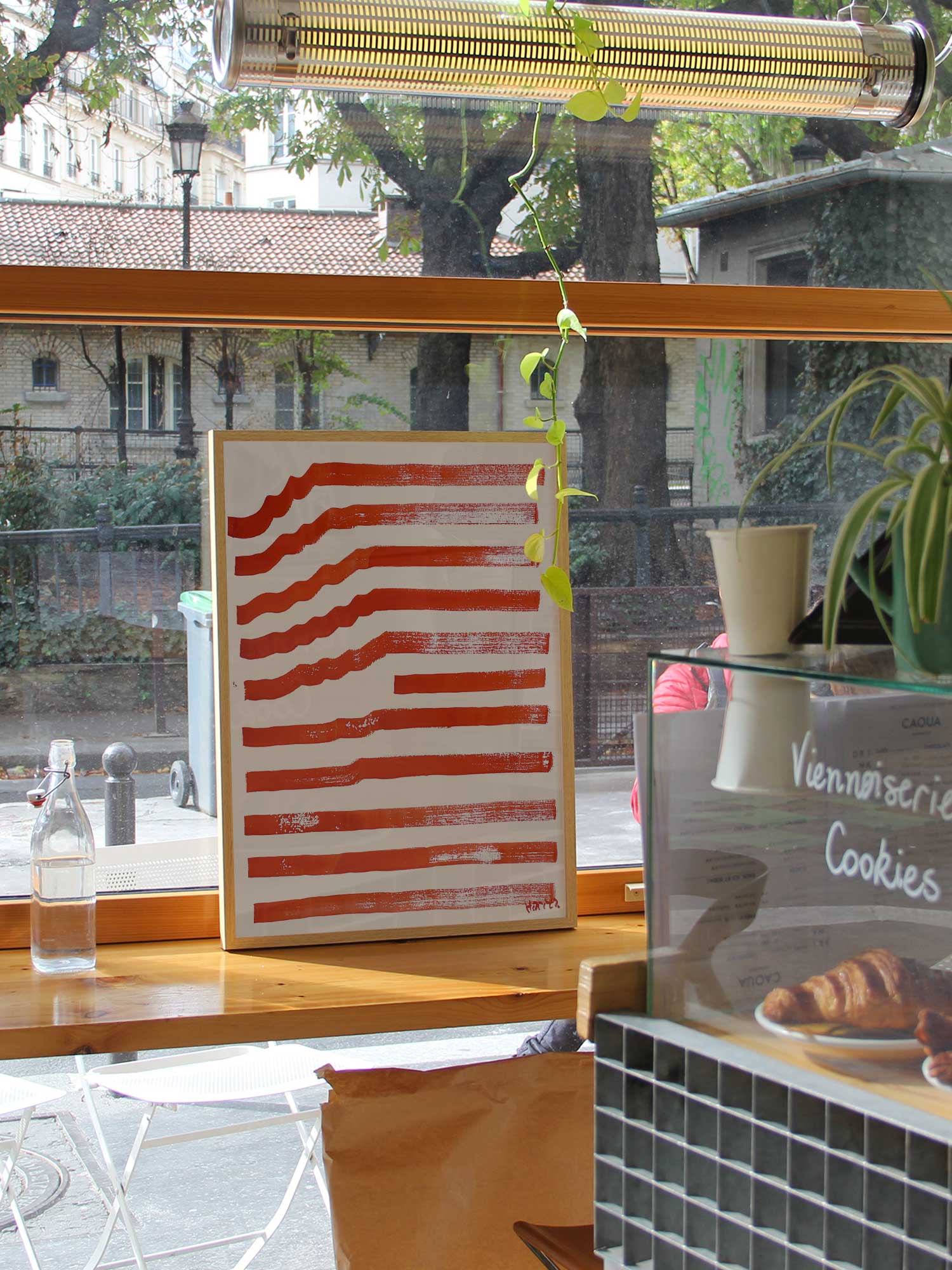 Affiche Ondes rouges de Haritz dans un coffee shop parisien lumineux et branché avec vue sur rue.