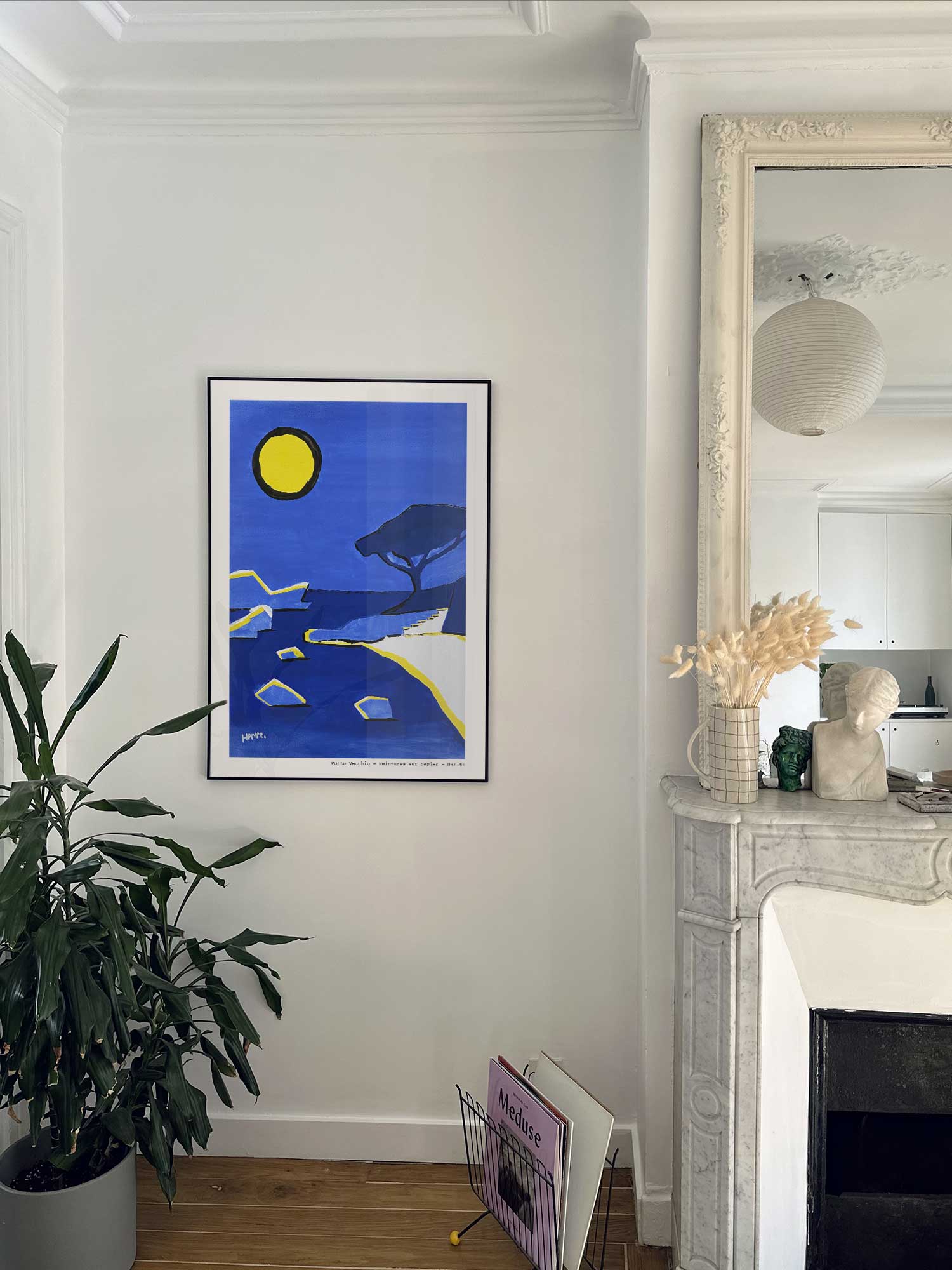 Affiche Porto Vecchio de Haritz accrochée au mur près d'une cheminée en marbre dans un appartement parisien.
