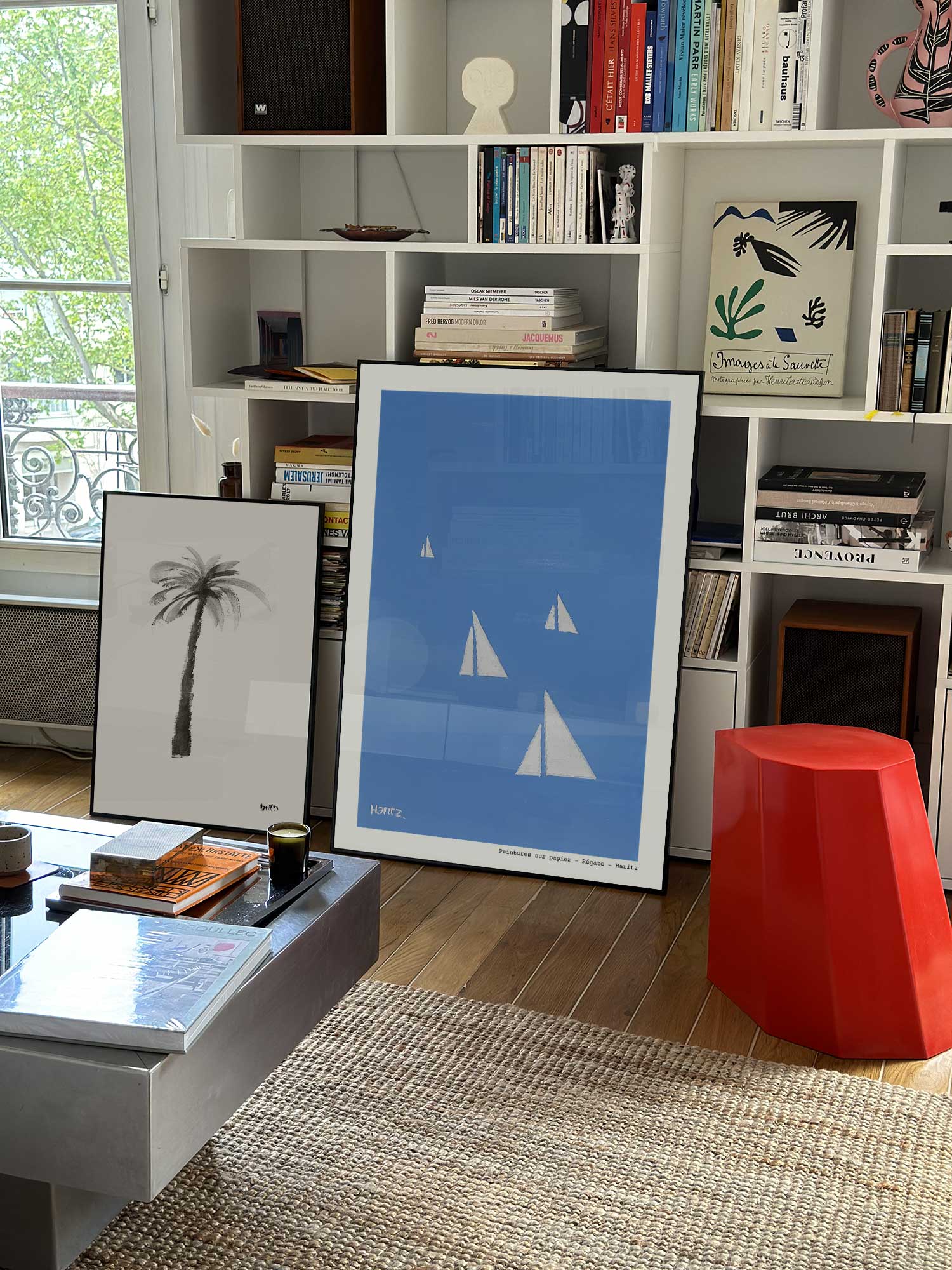 Affiche Régate de Haritz grand format dans un salon parisien design devant une bibliothèque blanche avec livres d'art.
