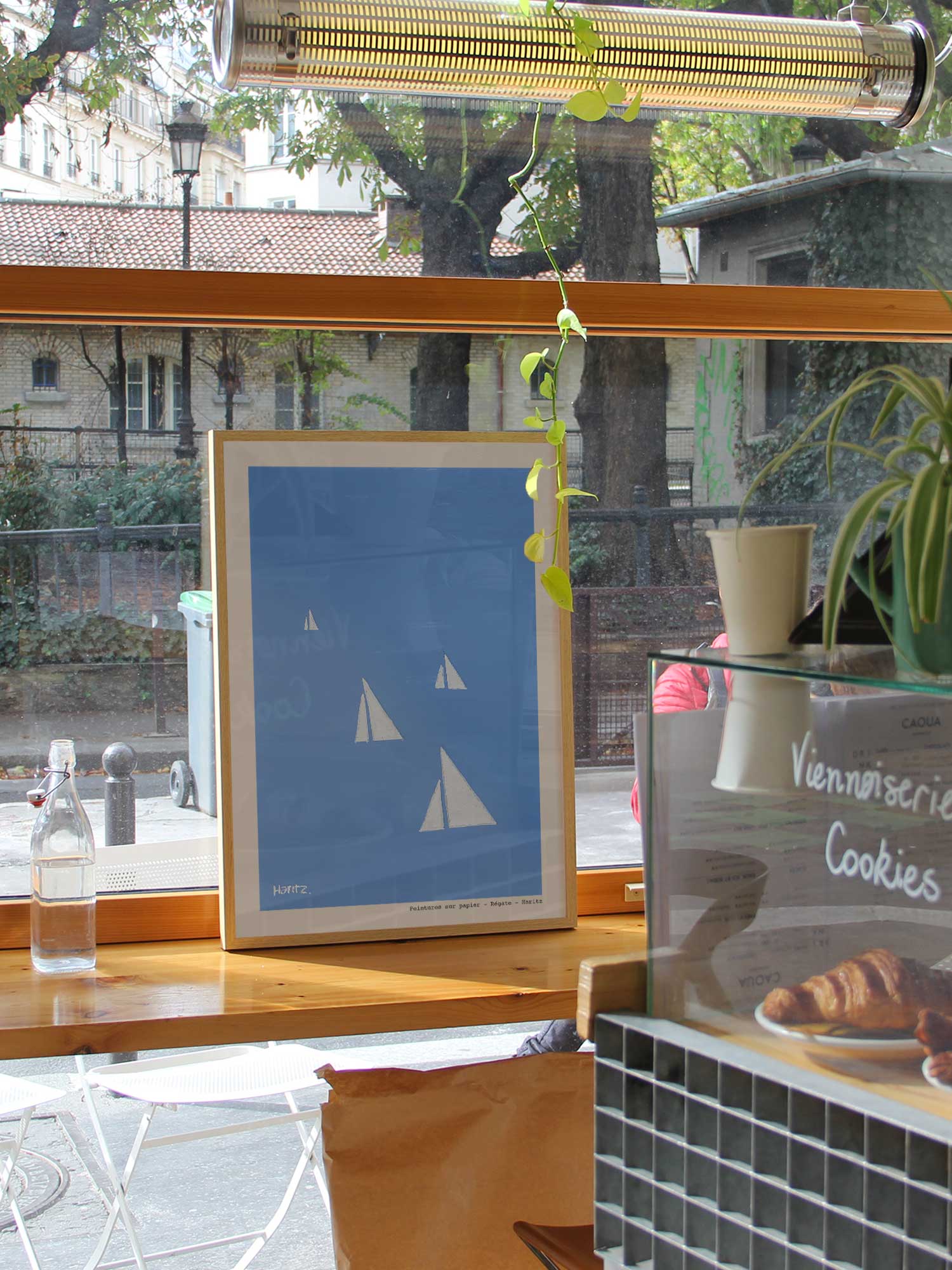 Affiche Régate de Haritz dans un coffee shop parisien lumineux et branché avec vue sur rue.