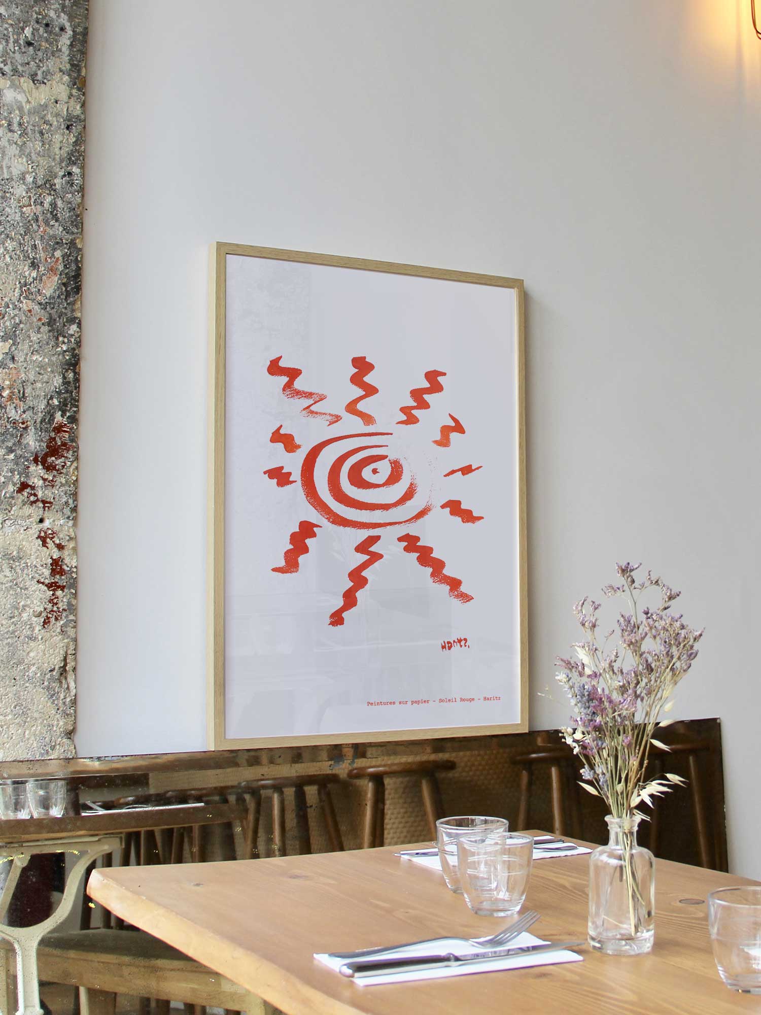 Affiche Soleil rouge de Haritz encadrée dans un restaurant bistrot parisien au style minimaliste et branché.