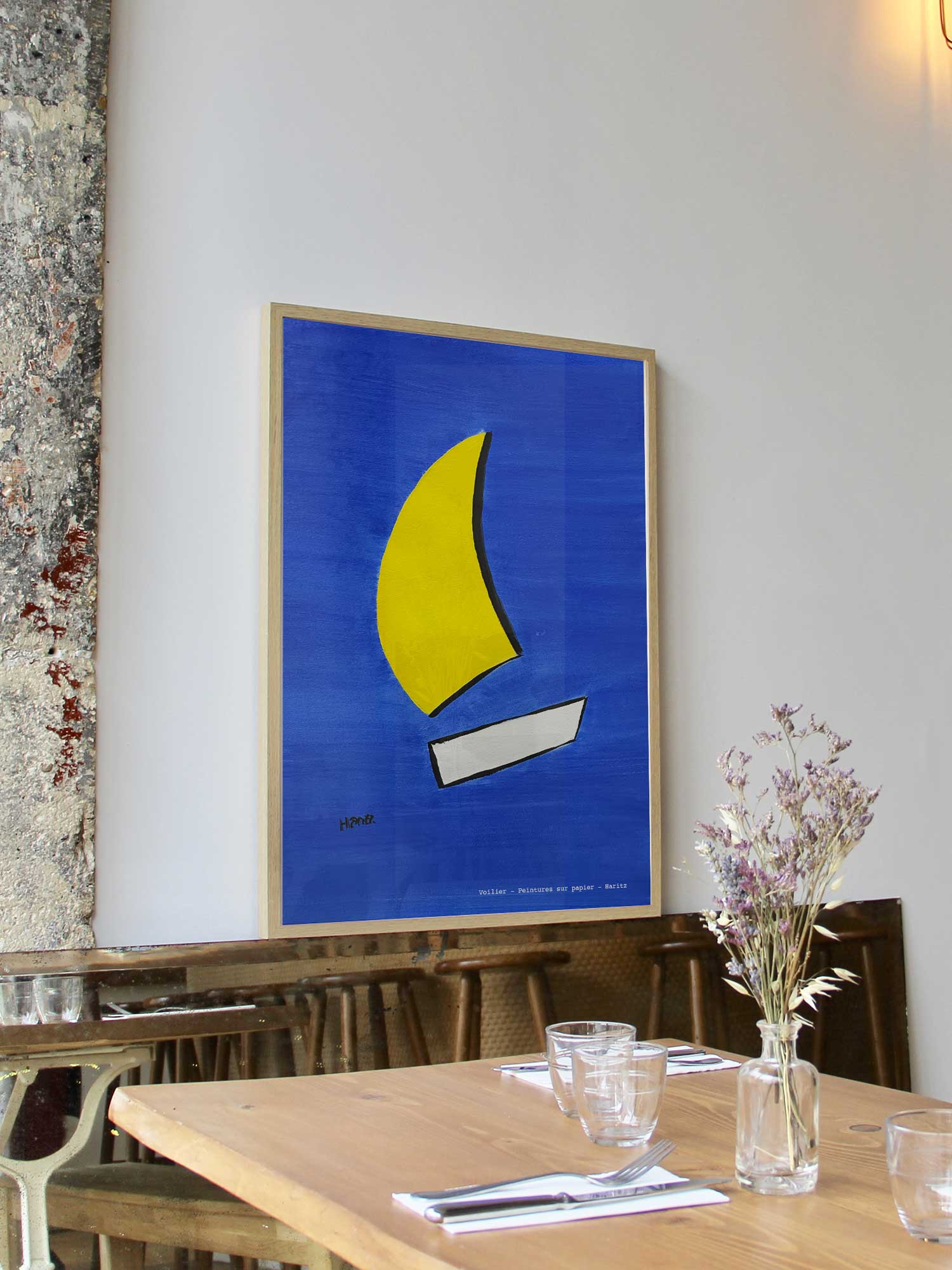 Affiche Voilier de Haritz encadrée dans un restaurant bistrot parisien au style minimaliste et branché.