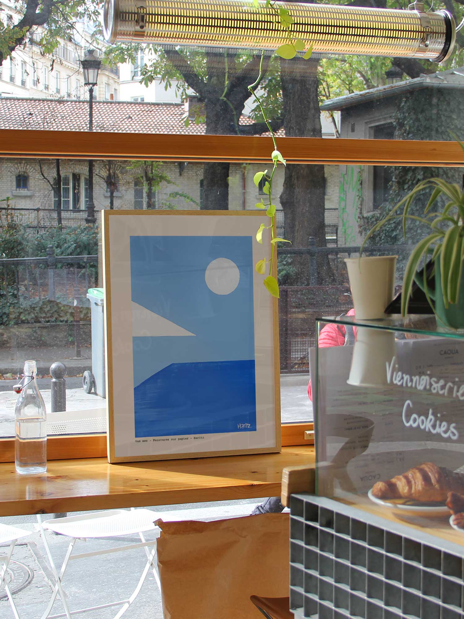 Affiche Vue mer de Haritz dans un coffee shop parisien lumineux et branché avec vue sur rue.