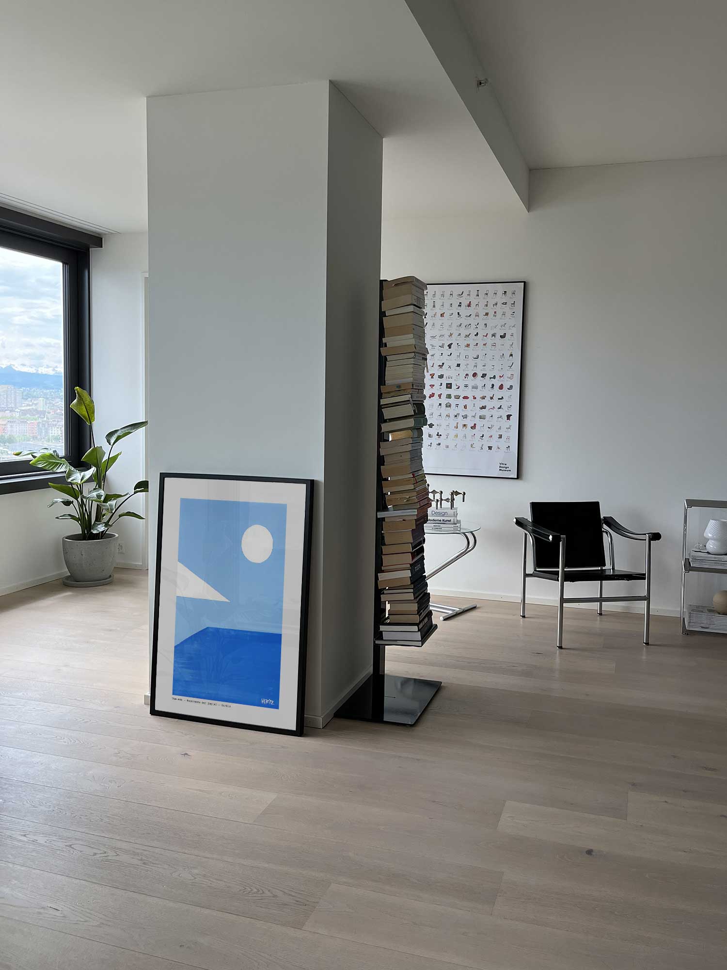 Affiche Vue mer de Haritz posée au sol dans un salon moderne et lumineux.