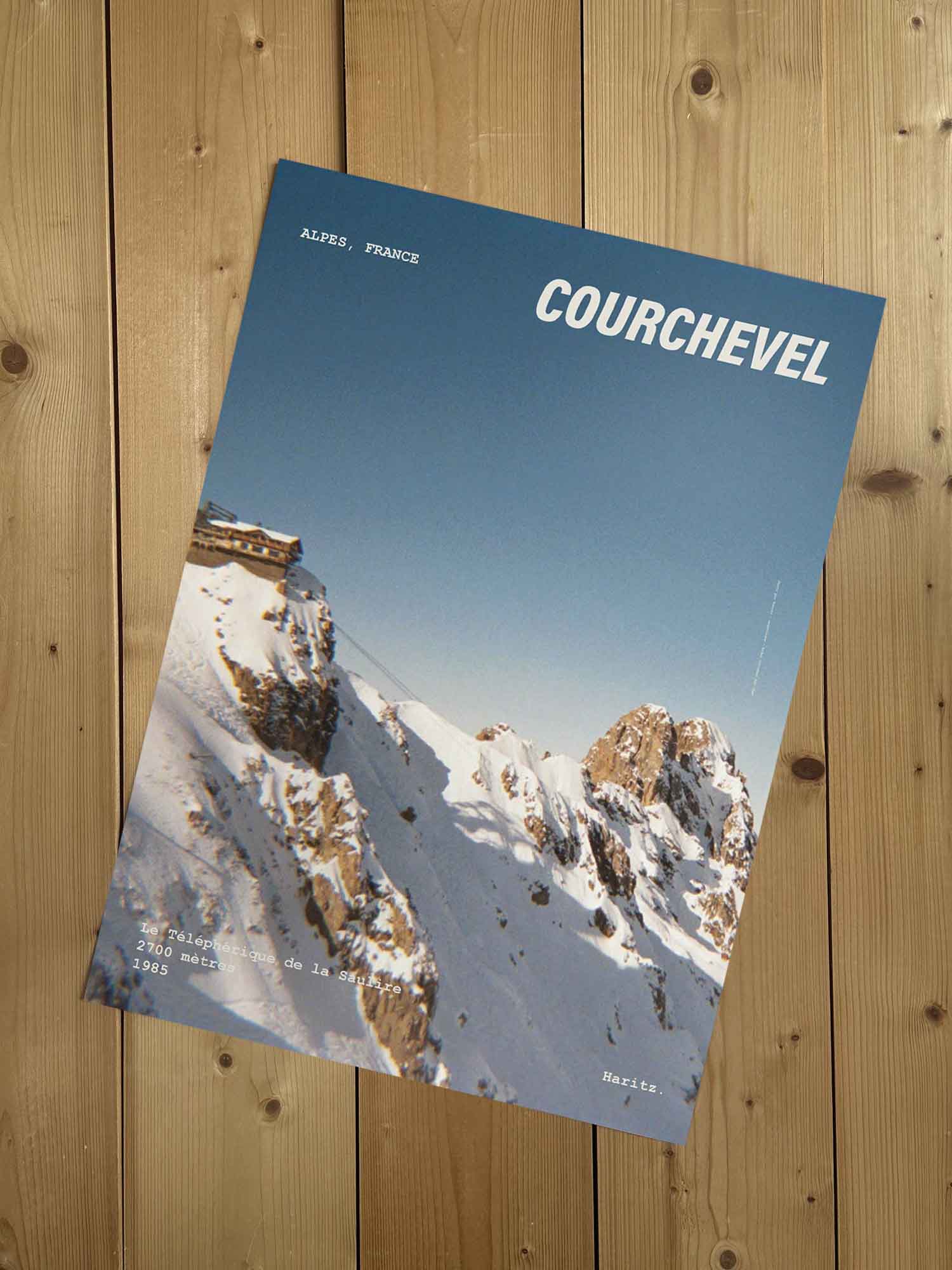 Affiche Courchevel vintage sans cadre posée sur parquet bois — téléphérique de la Saulire 2700 mètres, photographie argentique Haritz