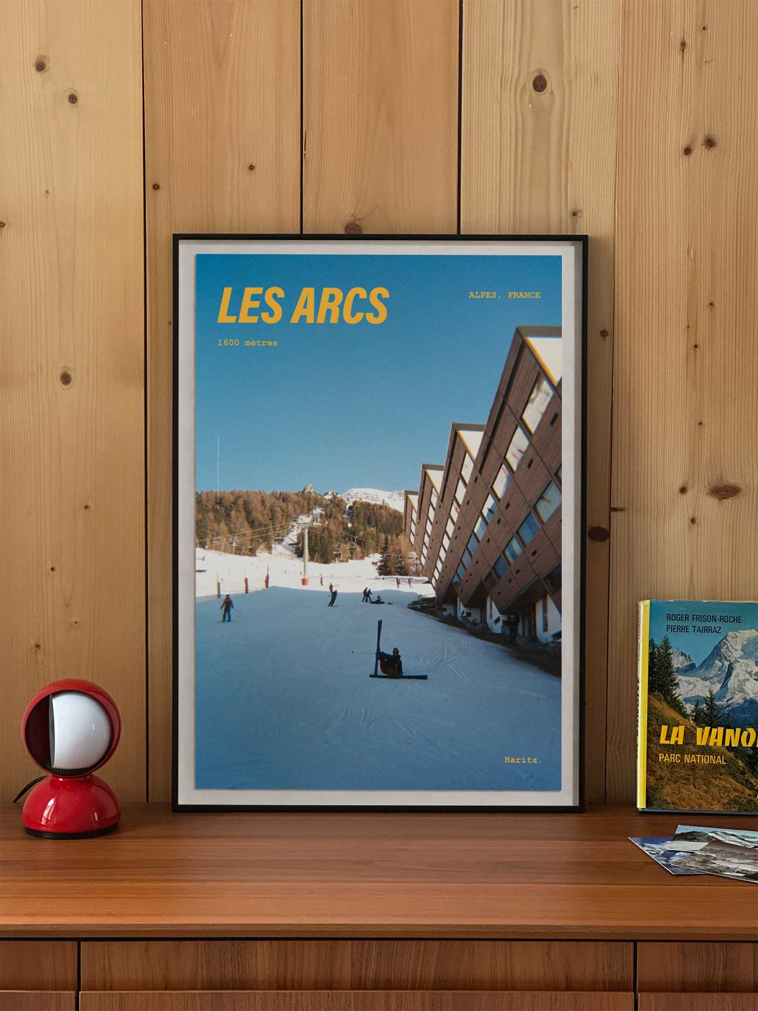 Affiche Les Arcs vintage encadrée posée sur meuble en bois — village Arc 1600 et pistes de ski, photographie argentique Haritz