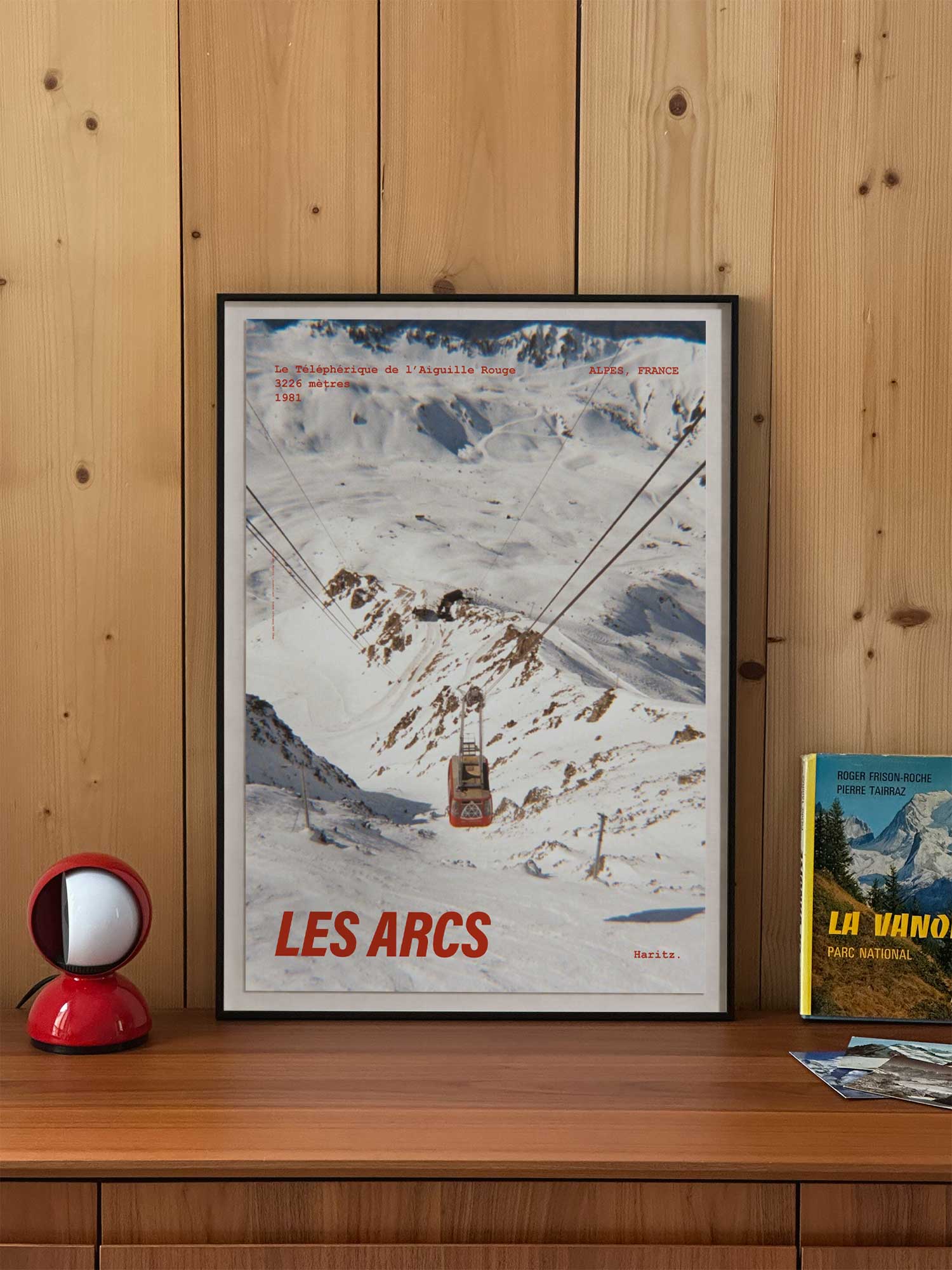 Affiche Les Arcs vintage encadrée posée sur un meuble en bois — téléphérique de l'Aiguille Rouge 1981, photographie argentique Haritz