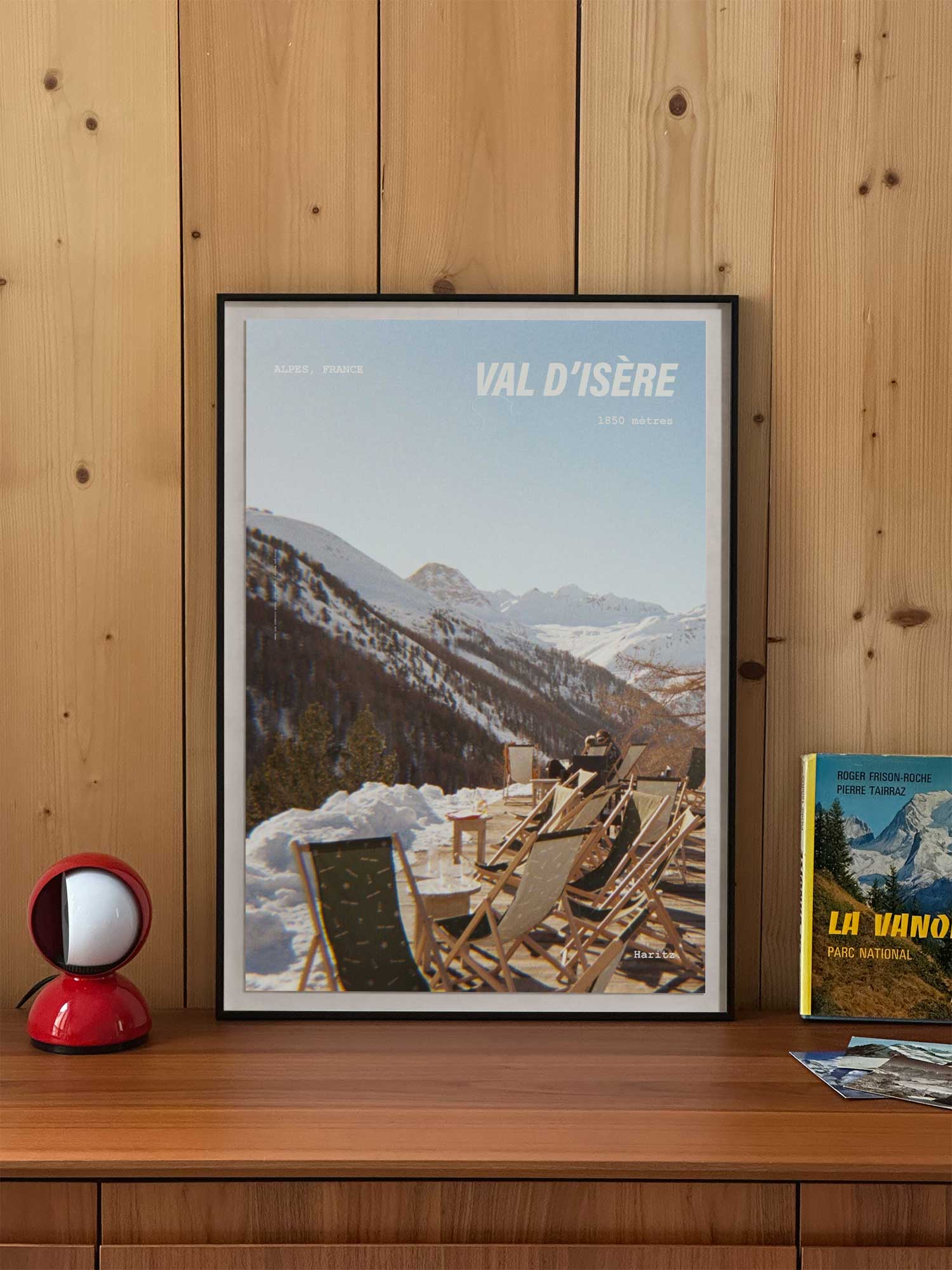 Affiche Val d'Isère vintage encadrée posée sur meuble en bois — transats en terrasse au soleil à 1850 mètres, photographie argentique Haritz