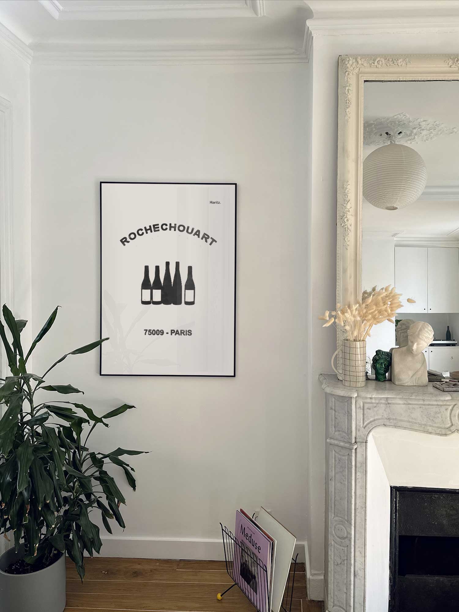 Affiche Rochechouart de Haritz accrochée au mur près d'une cheminée en marbre dans un appartement parisien.