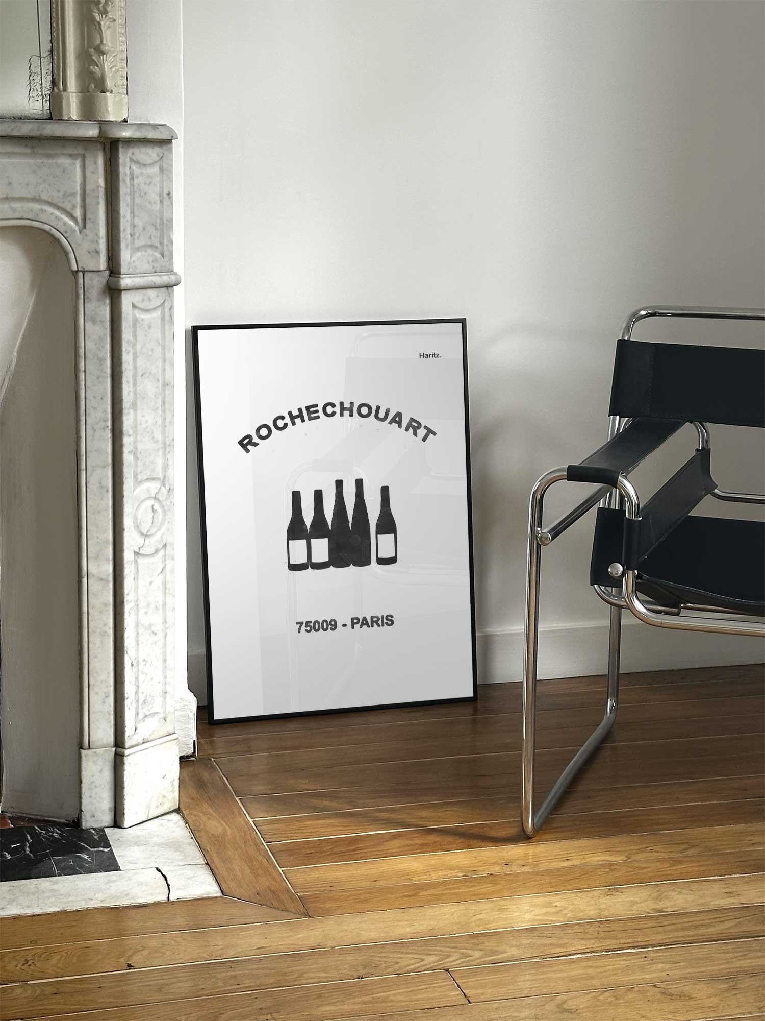 Affiche Rochechouart de Haritz posée près d'une cheminée en marbre avec chaise Design dans un salon d'appartement parisien.
