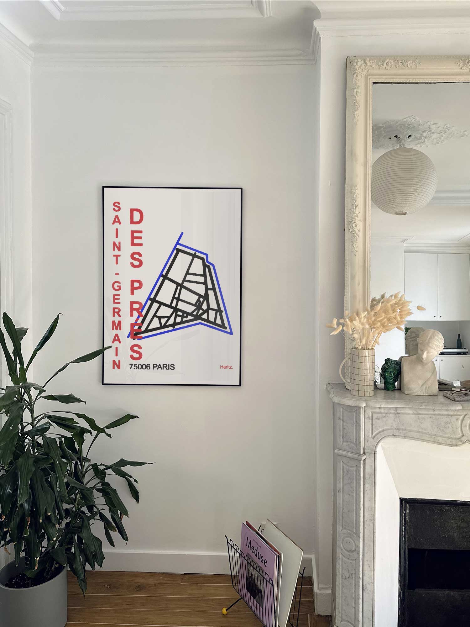 Affiche Saint Germain des Près de Haritz accrochée au mur près d'une cheminée en marbre dans un appartement parisien.
