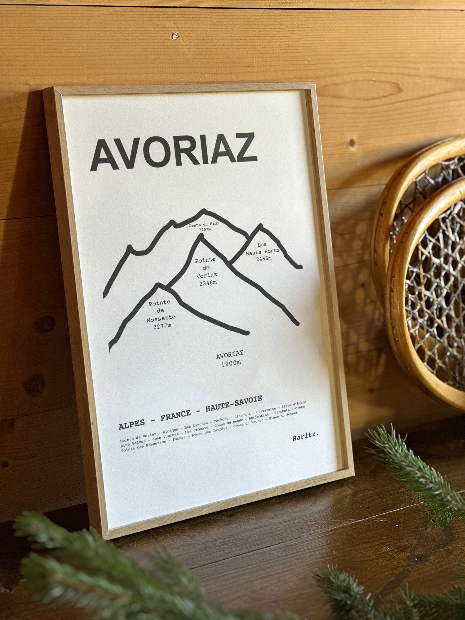 Affiche Avoriaz du tracé topographique des sommets dans un cadre en bois naturel, mise en scène dans une décoration chalet avec objets vintage et raquettes à neige, par Haritz.